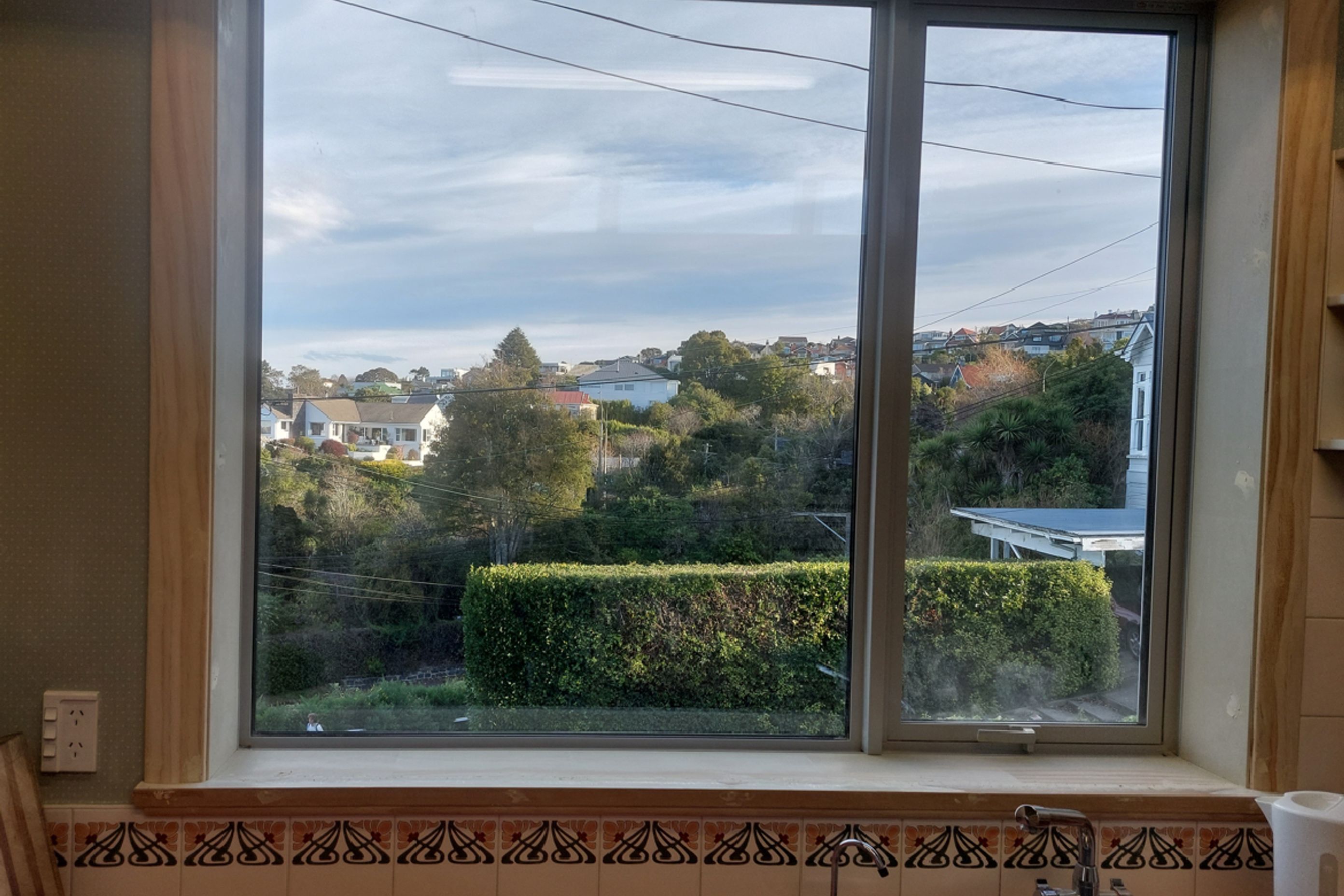 8-19-Tweed-St-Roslyn-Dunedin-Newly-installed-double-glazed-window-in-the-kitchen-being-stopped-and-sanded-on-the-reveal-and-trims-JDBuilders.jpg