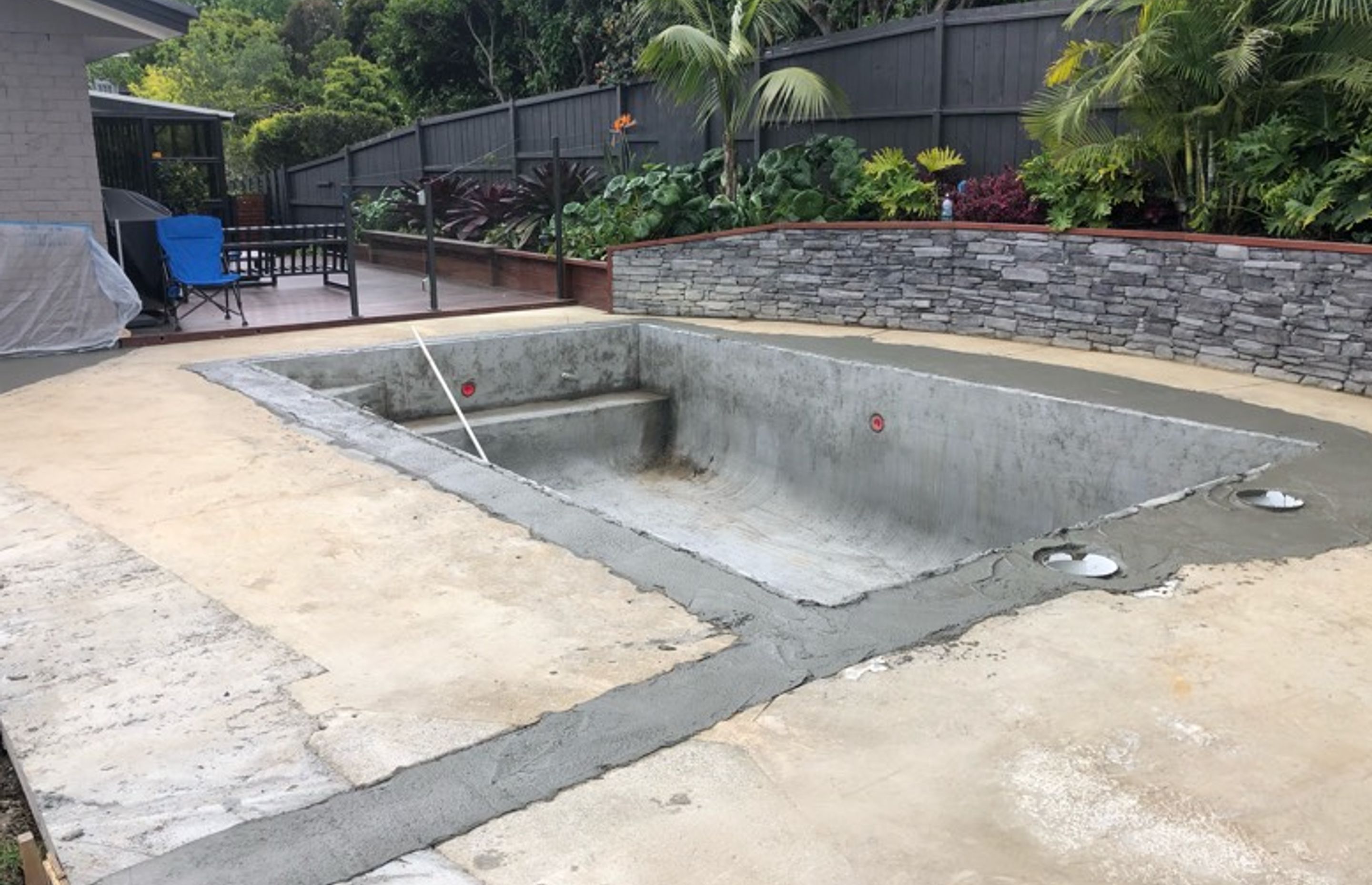A newly sprayed concrete pool - ground plumbing newly installed and the old pool shape is visible that has had freshly filled with poured concrete.  The pool area can now be prepped for laying of new pavers &amp; coping and the cosmetic works can begin on the pool interior, including new pool plant installed.