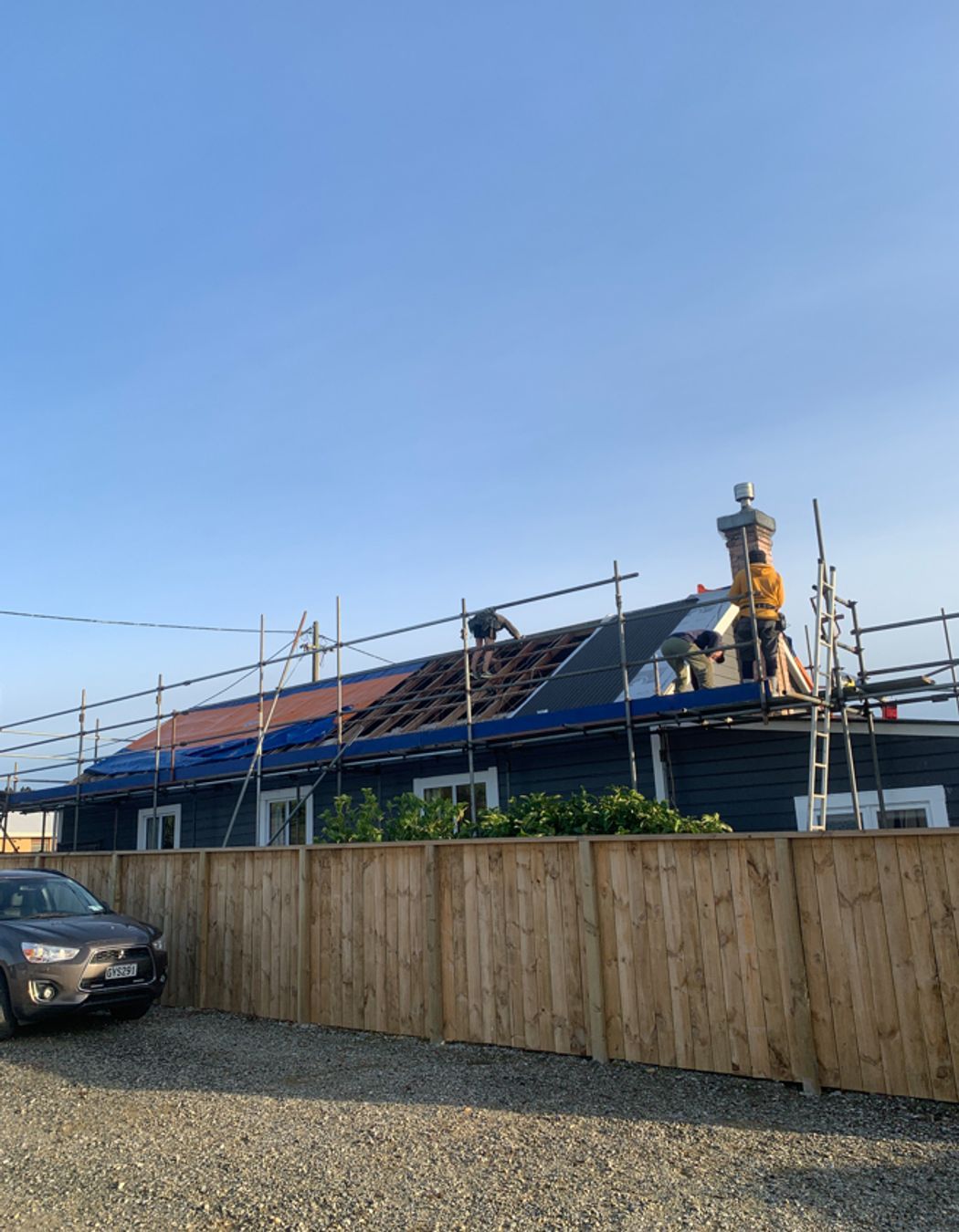 Reroofing underway, taking off the old roofing, repairing any damaged purlins and affixing new roofing underlay and sheets of long run roofing.