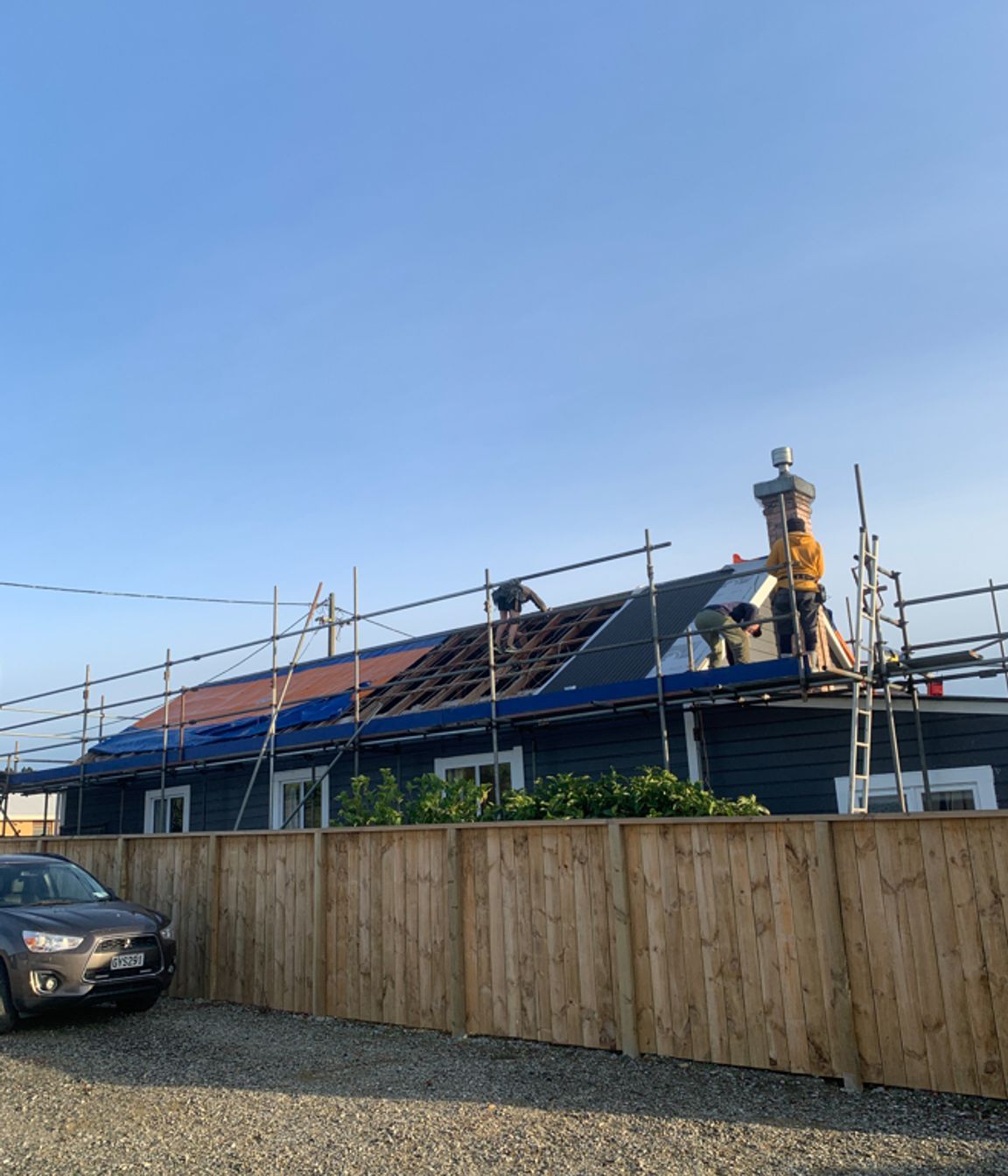 Reroofing underway, taking off the old roofing, repairing any damaged purlins and affixing new roofing underlay and sheets of long run roofing.