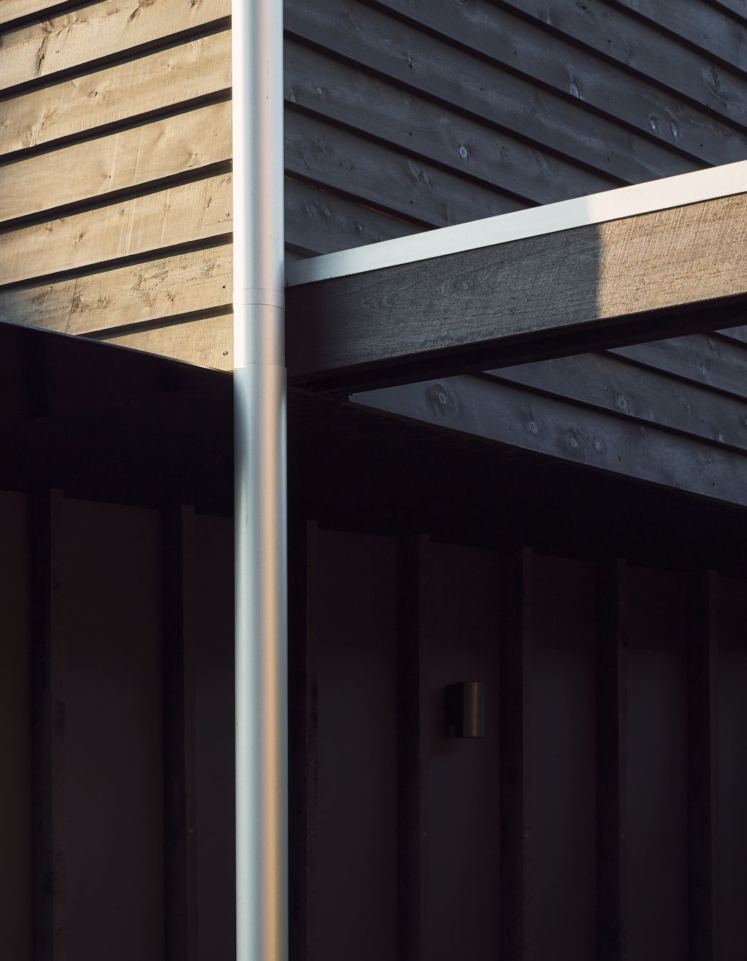 Black stained timber cladding and expressed battens create a muted silhouette for this traditional worker’s cottage, subtly revealing its character and texture throughout the day.