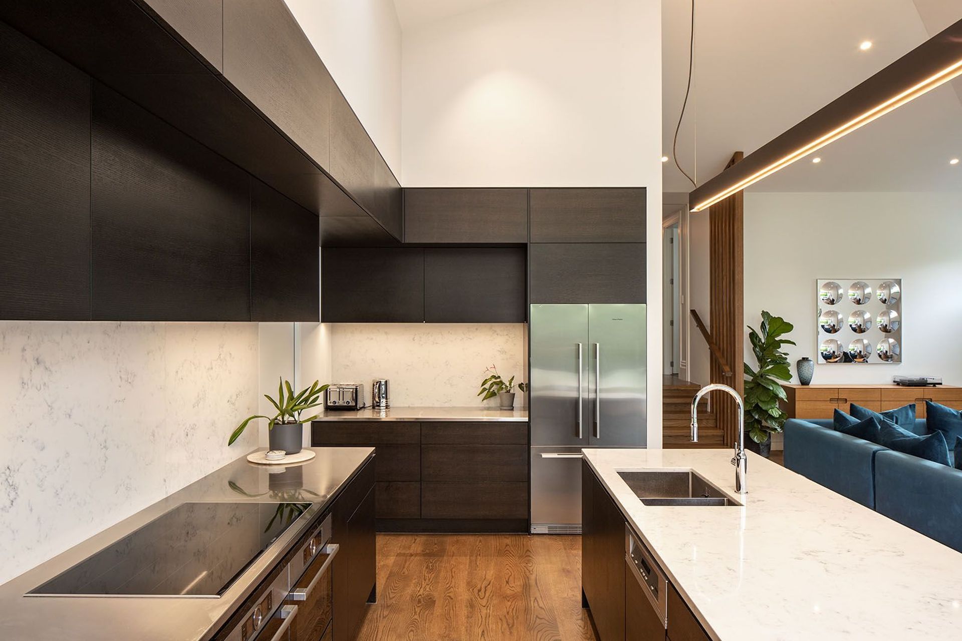 The combination of darkly stained cabinetry and neutral stone complements the timber flooring, while the galley style creates a very workable kitchen space.