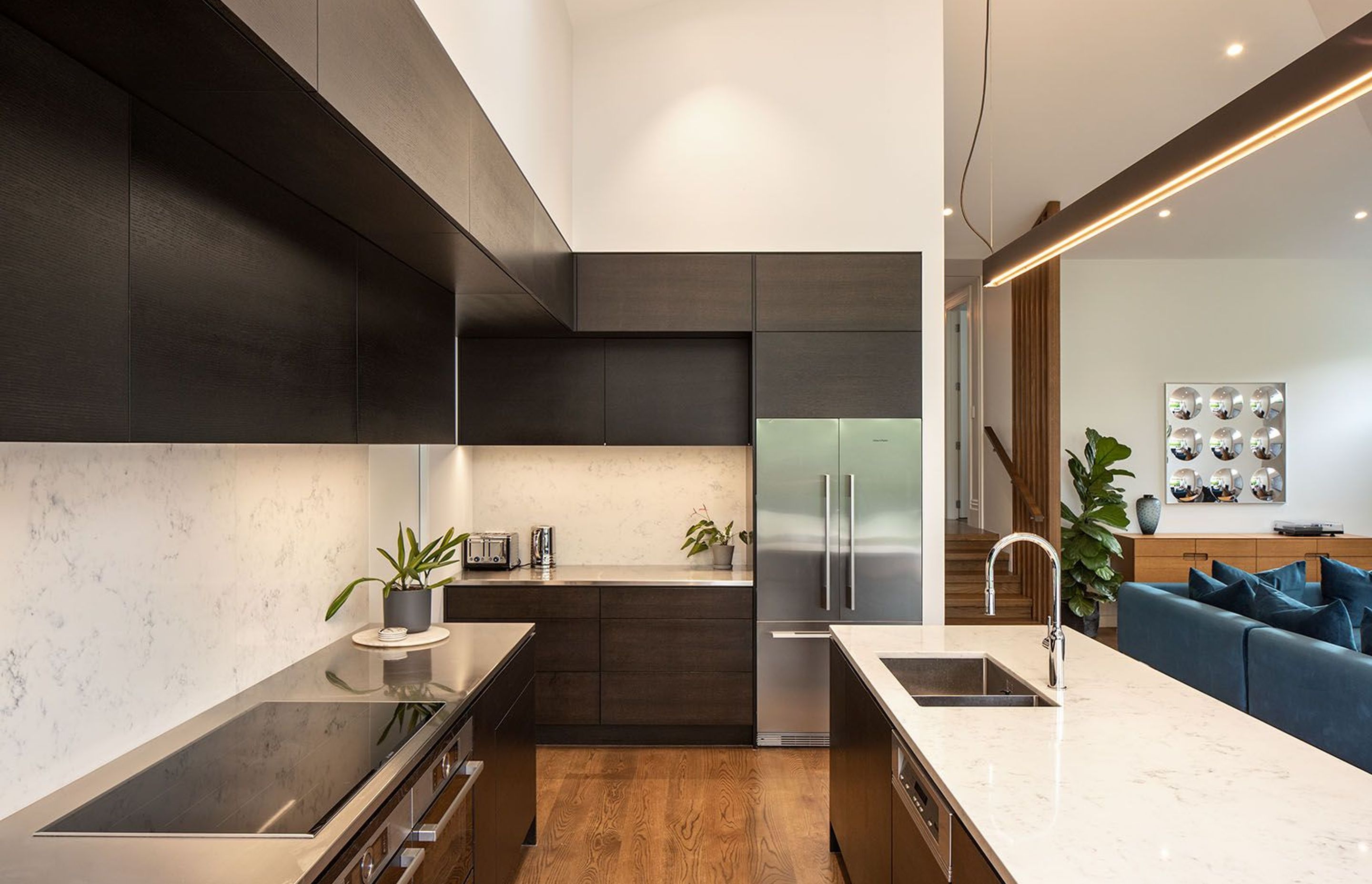 The combination of darkly stained cabinetry and neutral stone complements the timber flooring, while the galley style creates a very workable kitchen space.