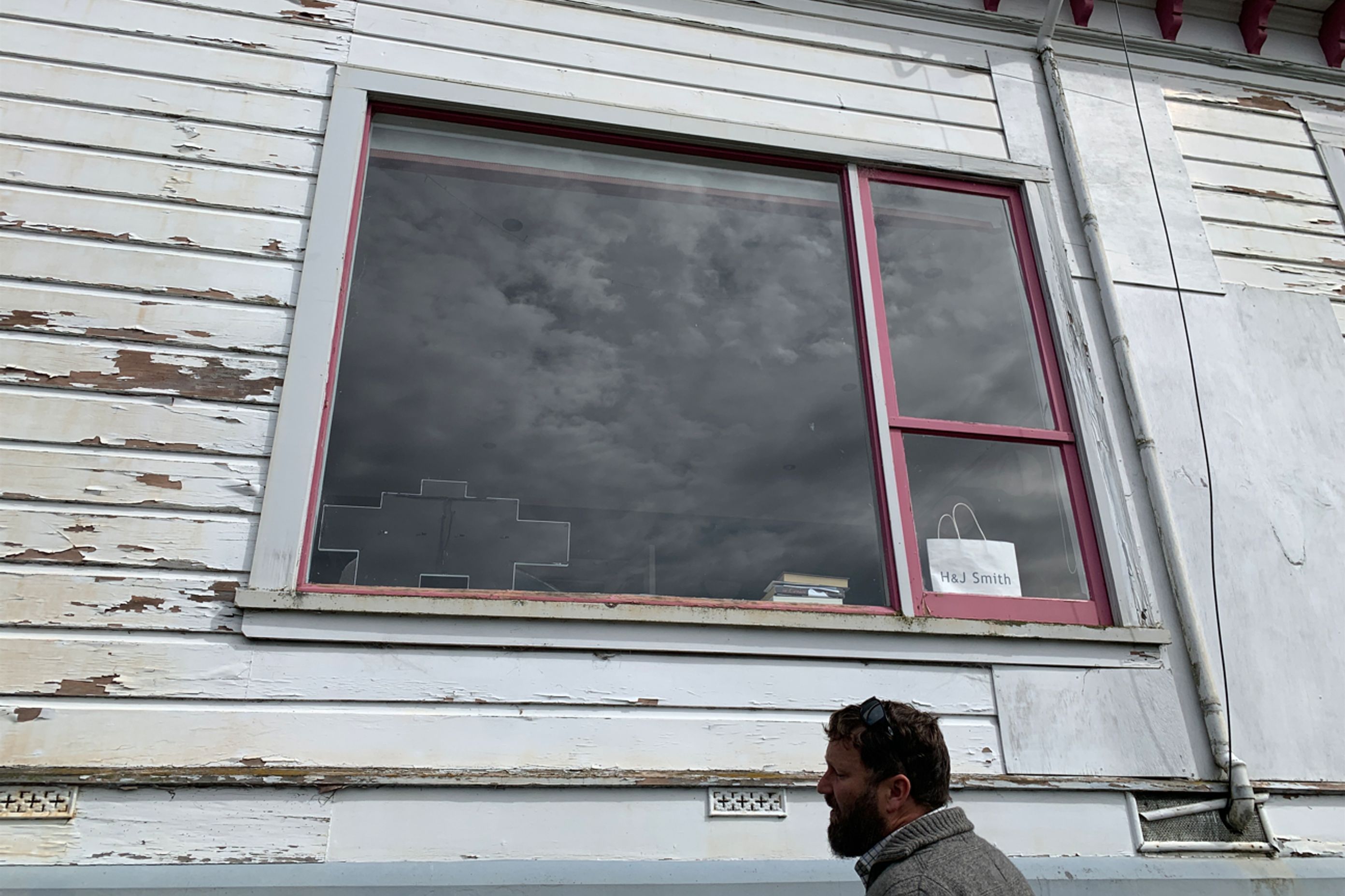 B5-9-Fifield-St-Roslyn-Dunedin-Jeff-inspecting-damaged-weatherboards-and-window-on-the-east-side-before-renovation-JDBuilders.jpg