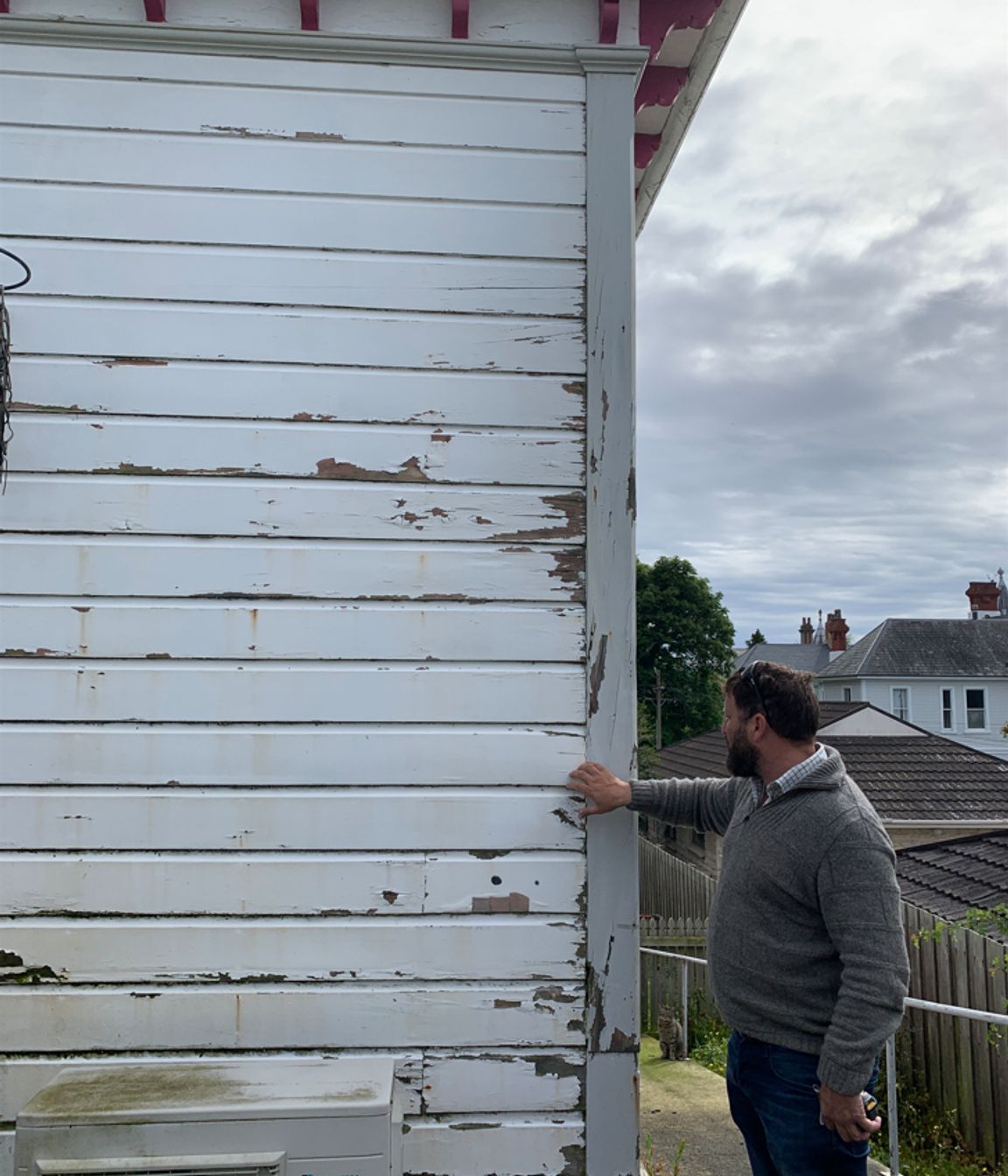 B7-9-Fifield-St-Roslyn-Dunedin-Jeff-inspecting-rotten-weatherboards-at-the-back-of-the-house-before-renovation-JDBuilders.jpg