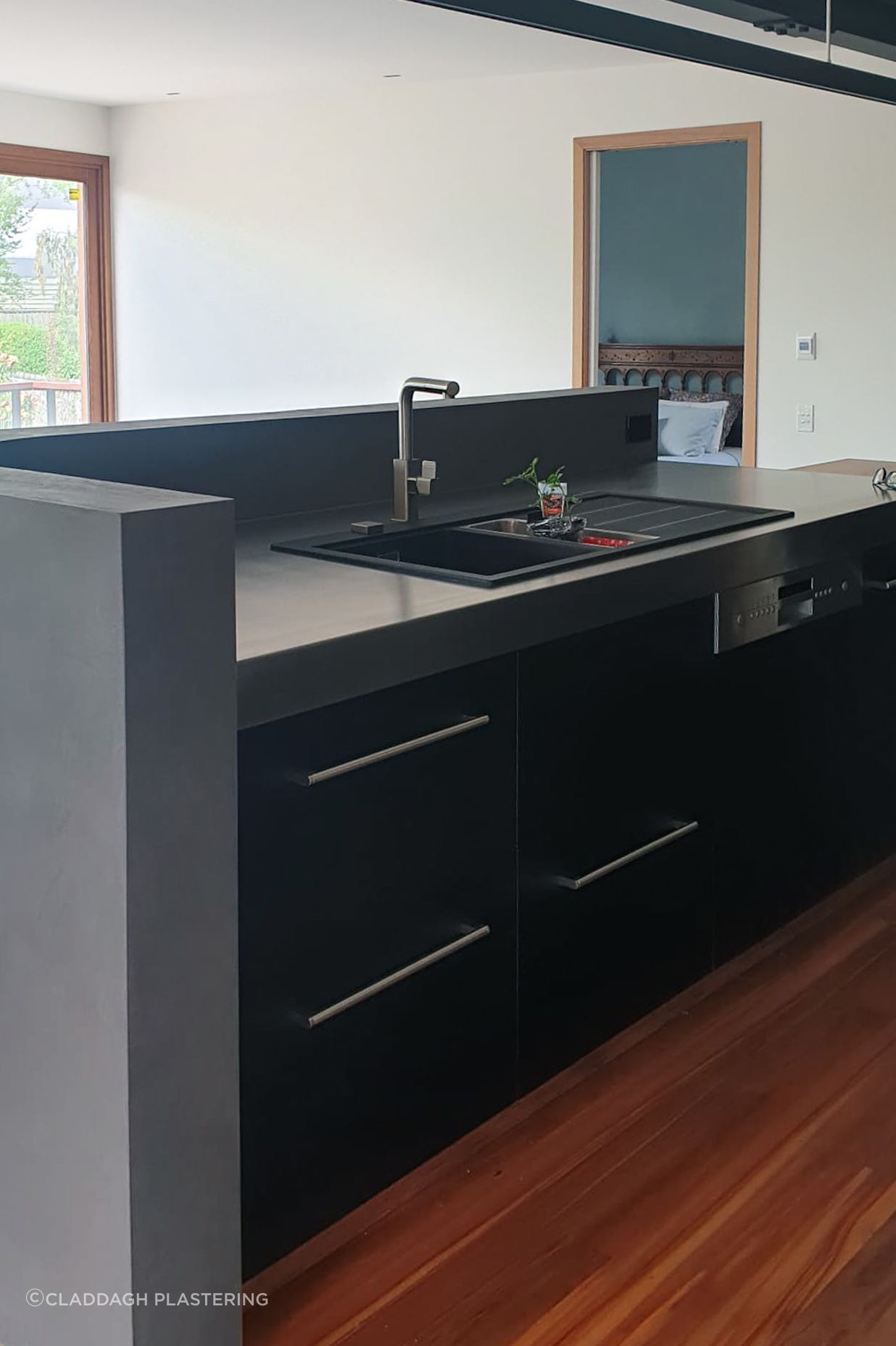 Dark polished plaster applied to the inside of this curved wall for the splashback.