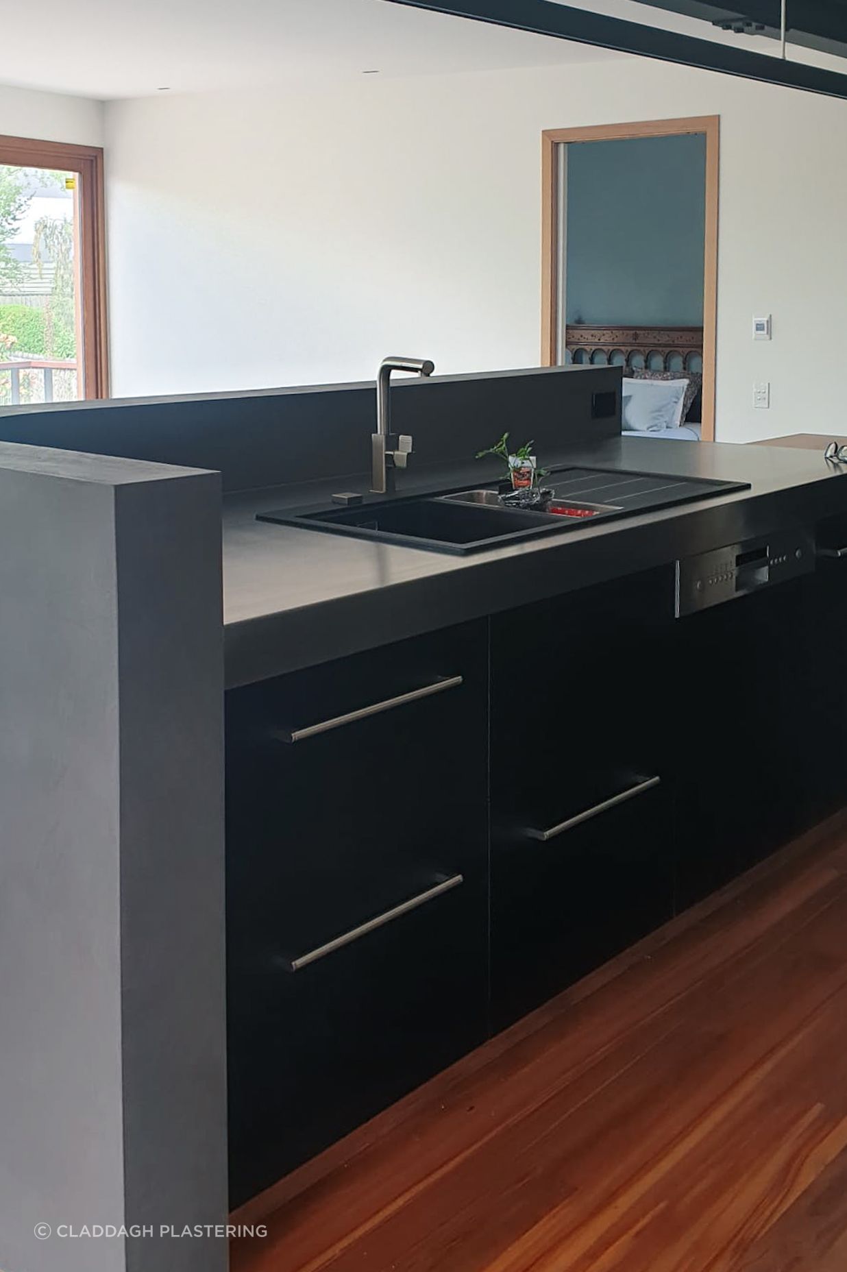Dark polished plaster applied to the inside of this curved wall for the splashback.