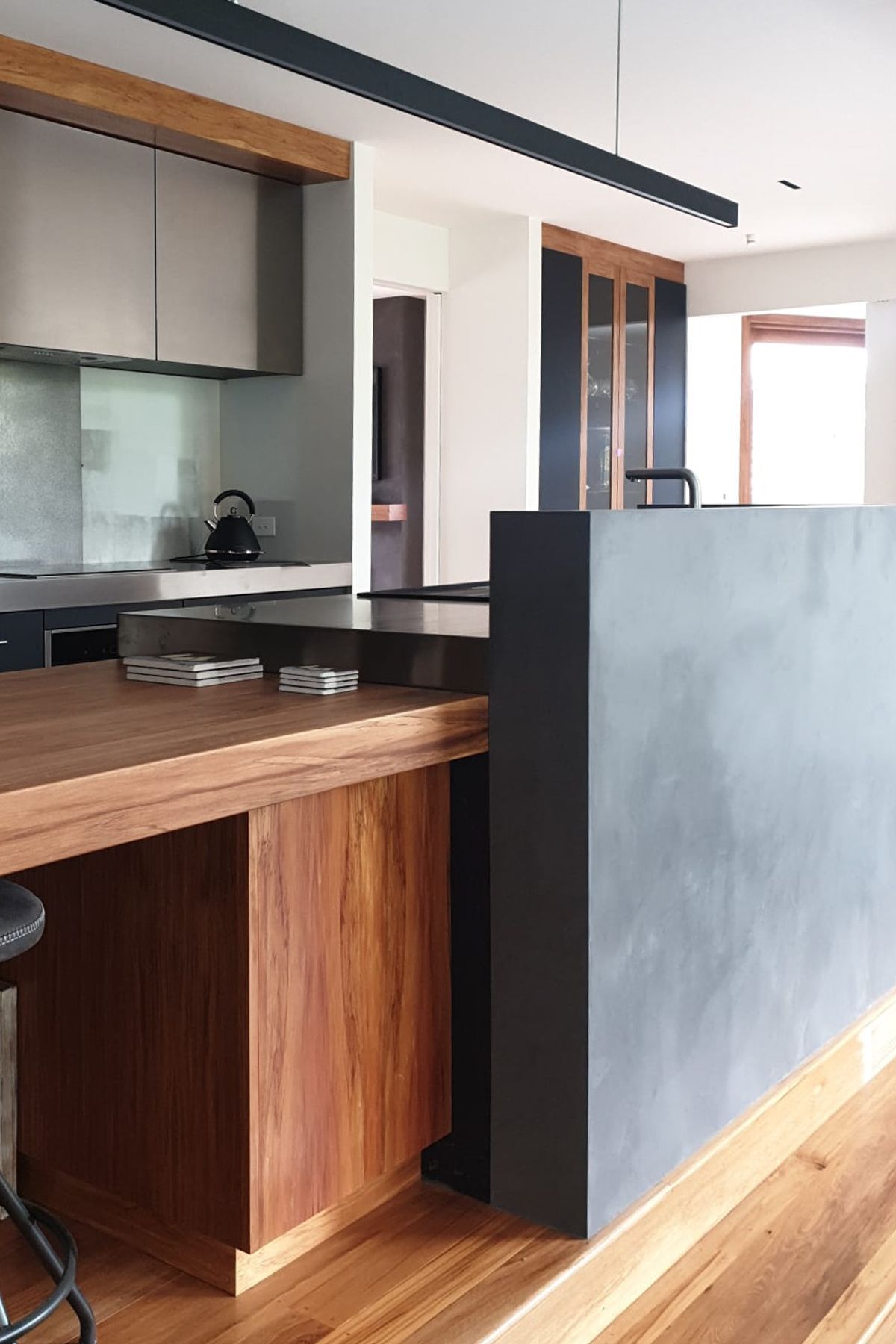 Tinted polished plaster to a dark colour and applied to this curved kitchen wall