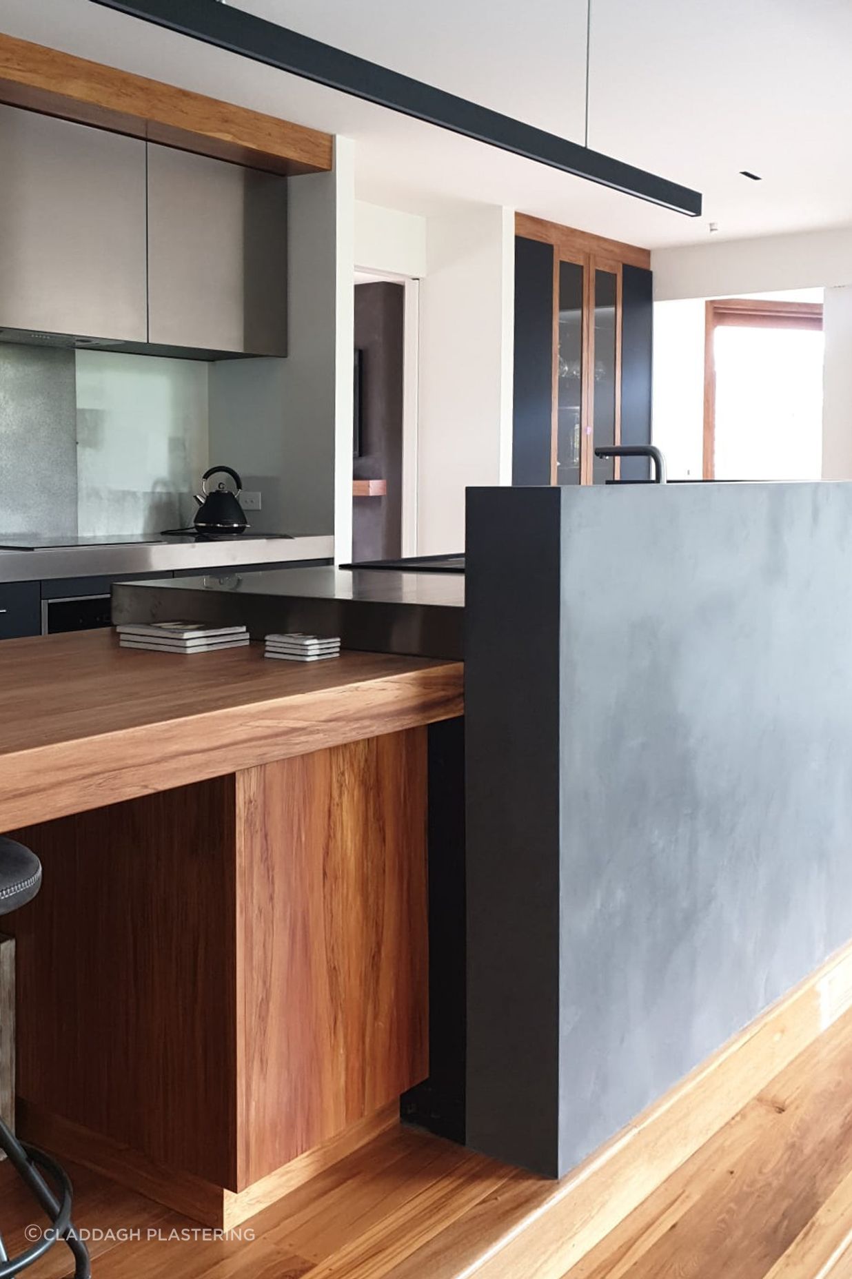Tinted polished plaster to a dark colour and applied to this curved kitchen wall