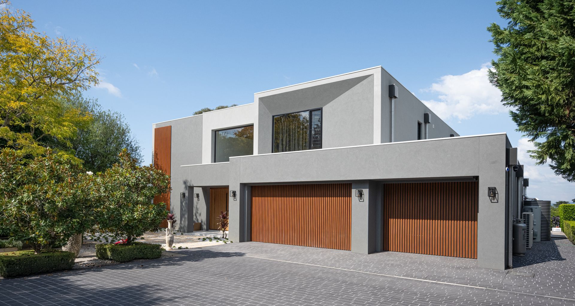 Custom Batten Sectional Door vertically cladded with Ironbark Decowood Battens, fixed with Colorbond Monument sheeting