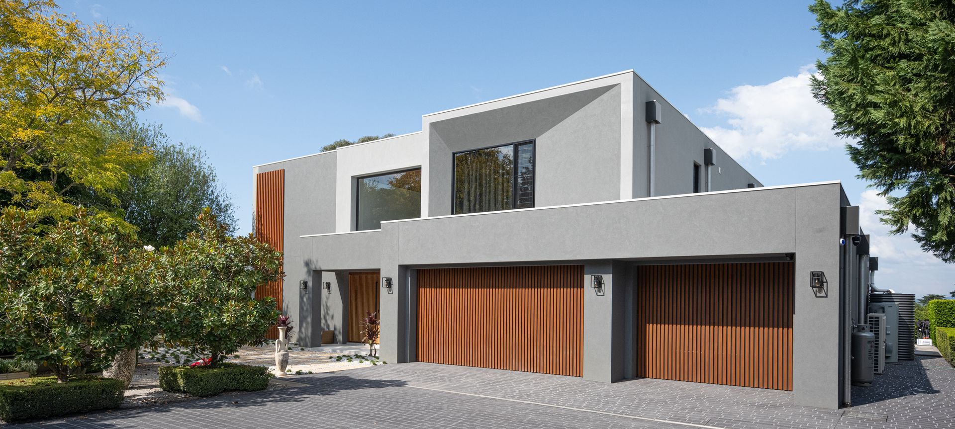 Custom Batten Sectional Door vertically cladded with Ironbark Decowood Battens, fixed with Colorbond Monument sheeting
