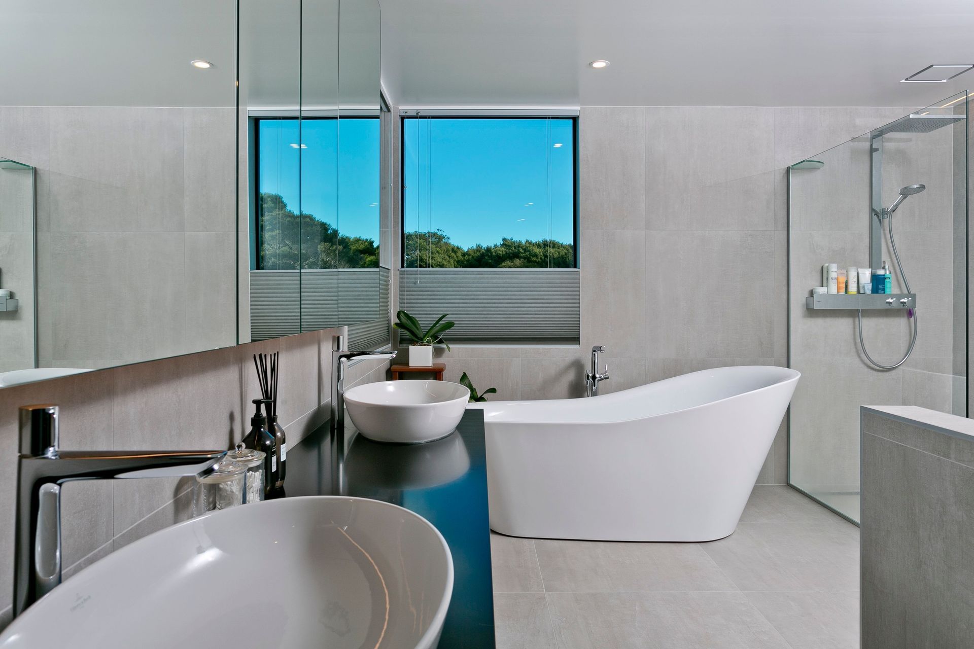 Large-format, stone-look tiles help impart a sense of spaciousness in the ensuite bathroom, which enjoys a crisp, contemporary look.