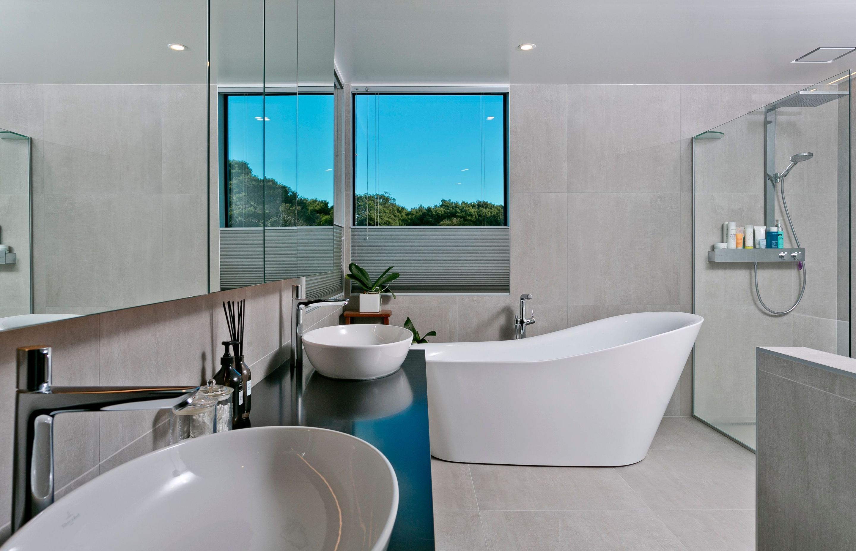 Large-format, stone-look tiles help impart a sense of spaciousness in the ensuite bathroom, which enjoys a crisp, contemporary look.