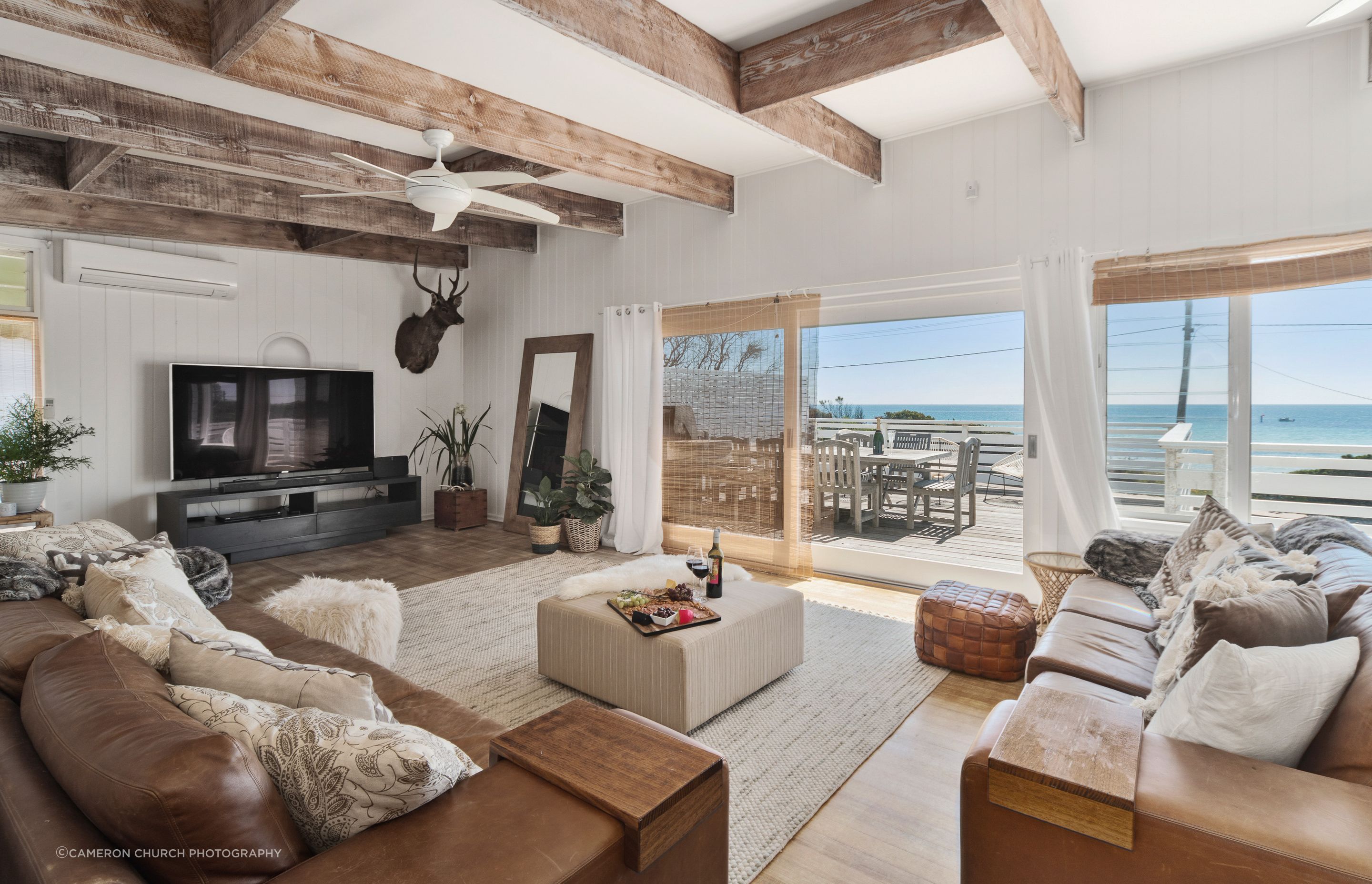 Indulge in coastal bliss at Fishermans' Cottage. Admire breathtaking views from the elegant living room overlooking Fishermans' Beach.