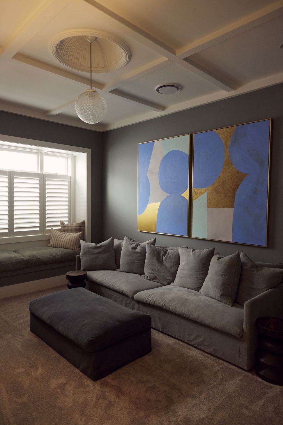 The media room at Point Chevalier Bungalow — coffered ceiling, deep charcoal tones, built-in window seat and large format artwork creating a considered retreat within the original bungalow. In collaboration with Hannah Warren Interiors.