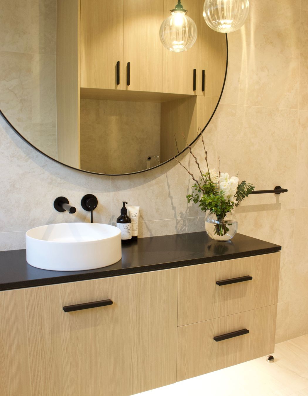 This stylish floor to ceiling tiled bathroom was a welcomed addition second bathroom and combined laundry to this family's villa