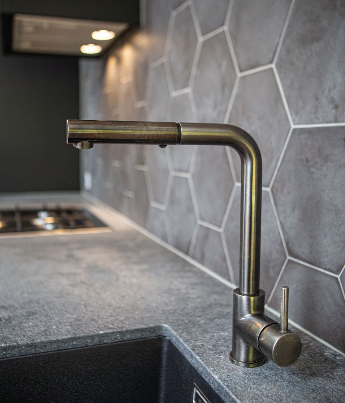 Gun metal kitchen mixer with square spout and Ceasarstone rugged concrete benchtop.