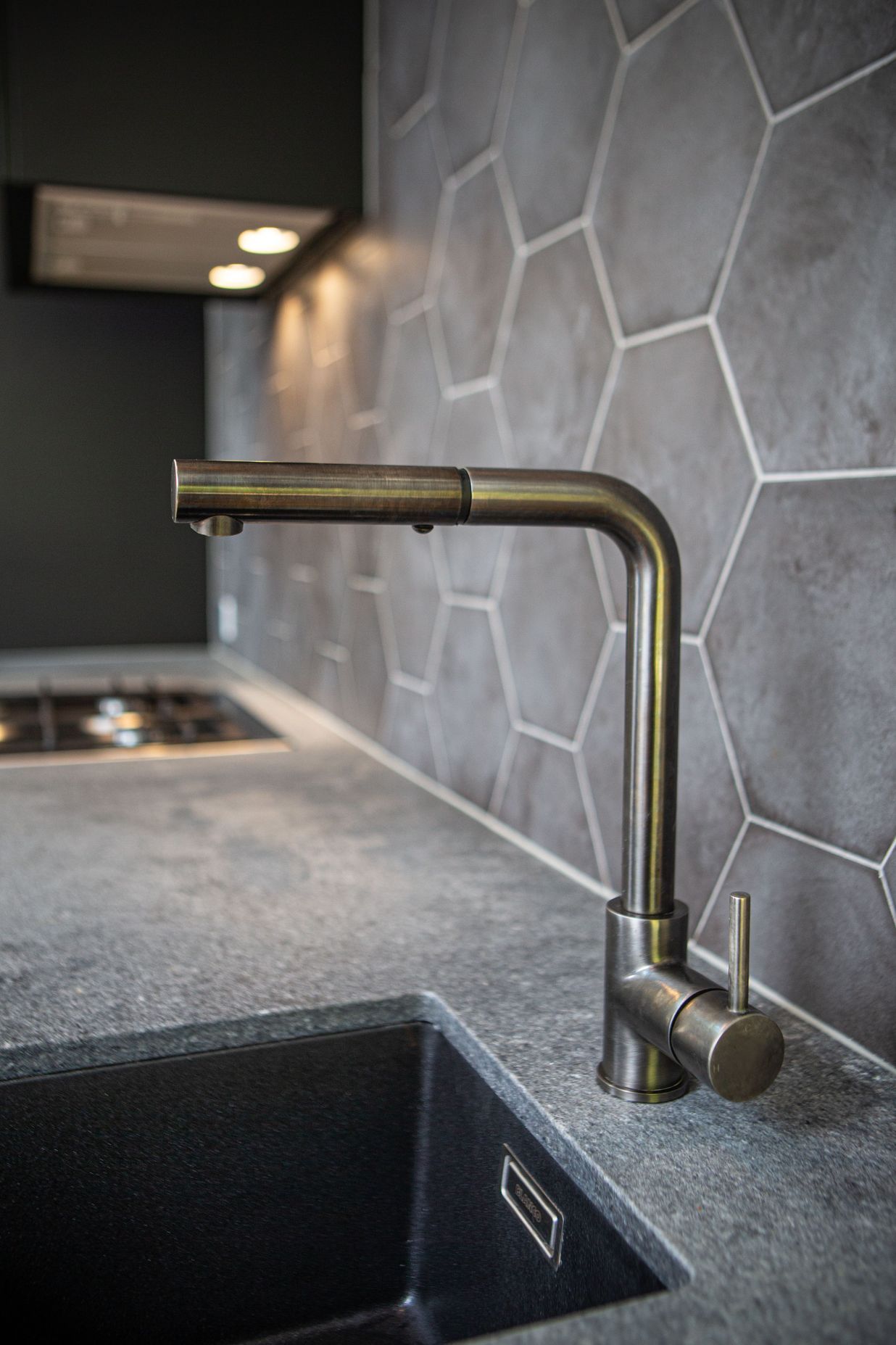 Gun metal kitchen mixer with square spout and Ceasarstone rugged concrete benchtop.