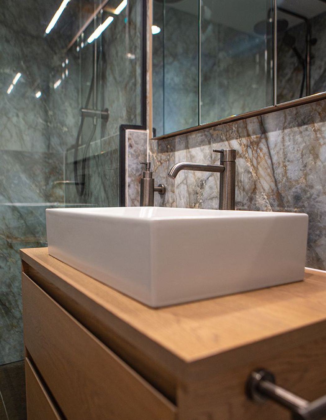 A rectangular vessel basin sits atop the oak two-drawer vanity.