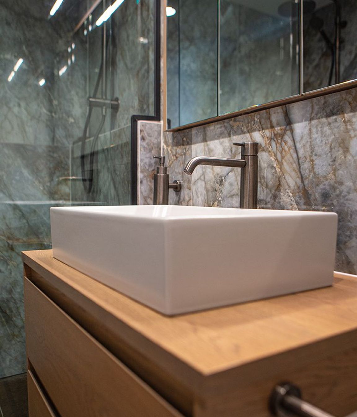 A rectangular vessel basin sits atop the oak two-drawer vanity.