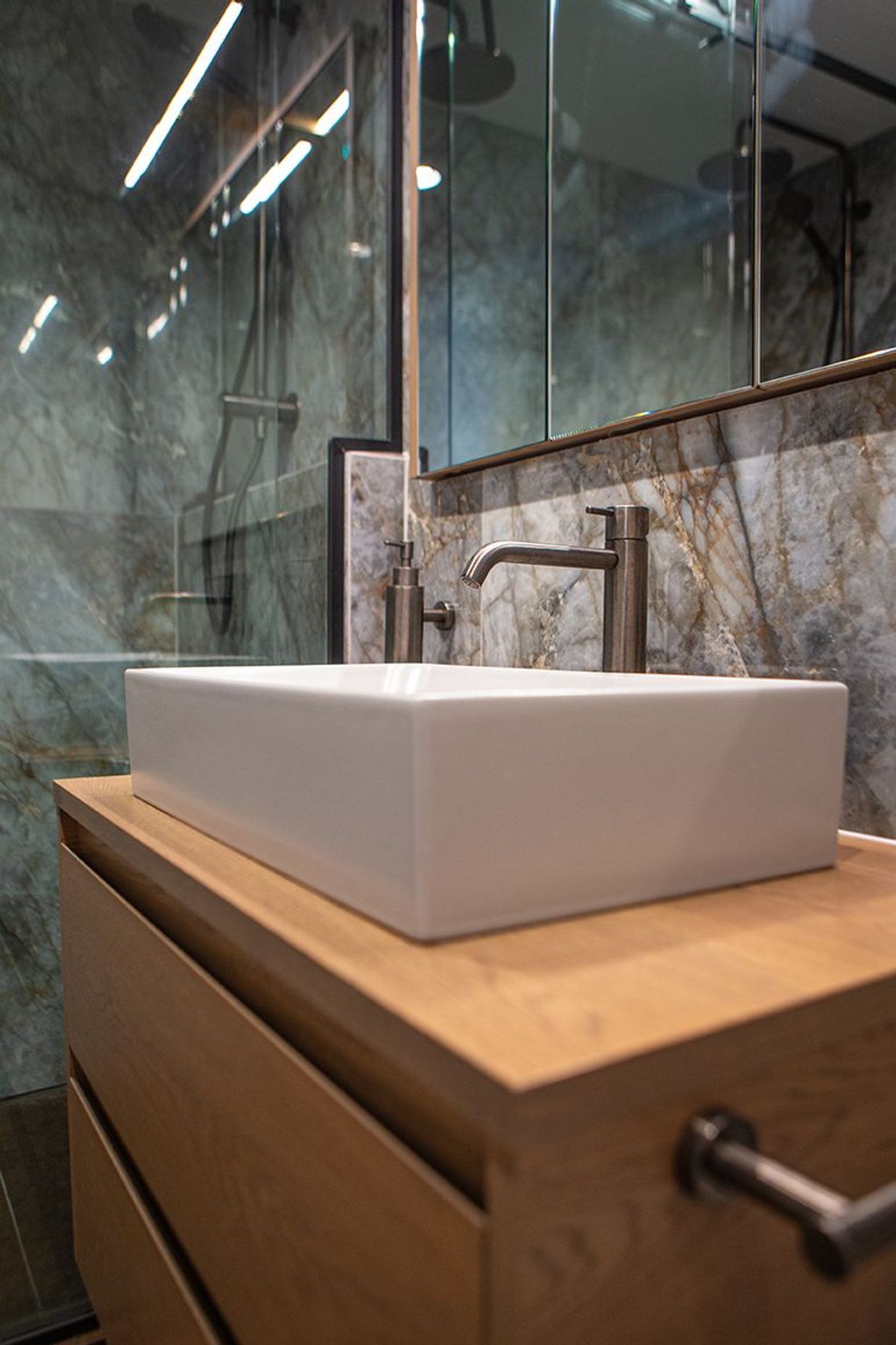 A rectangular vessel basin sits atop the oak two-drawer vanity.