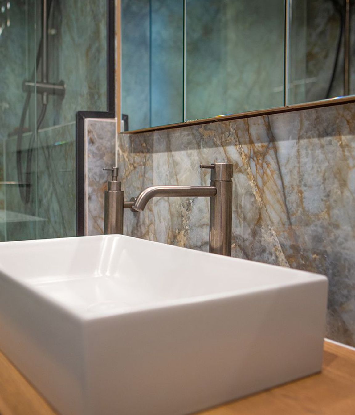 Aged iron wall mounted soap dispenser keeps the counter top clear.