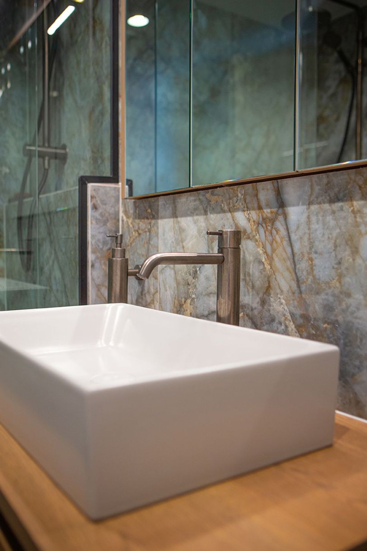 Aged iron wall mounted soap dispenser keeps the counter top clear.