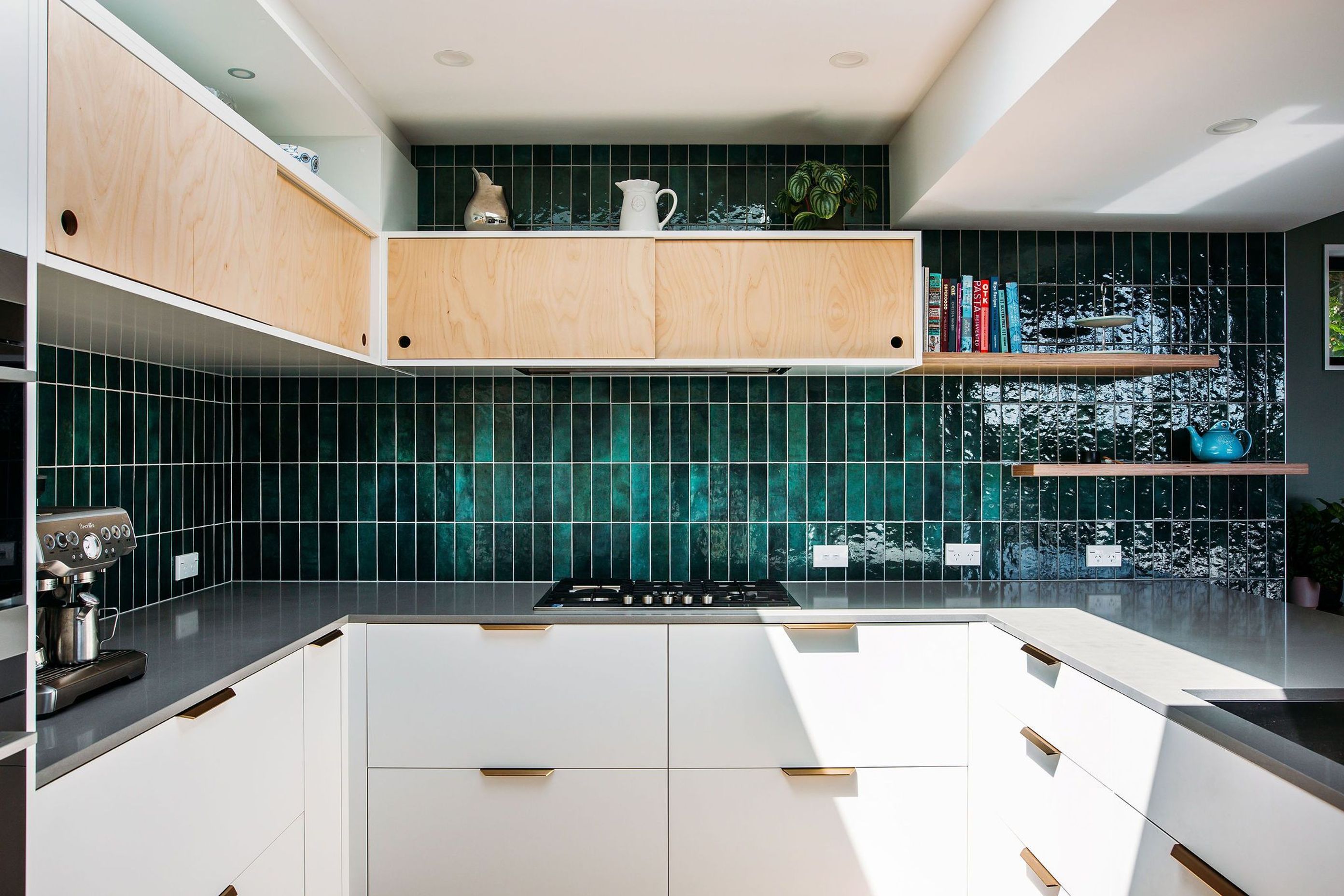 Simple plywood sliding cabinets above, brass pull handles below.
