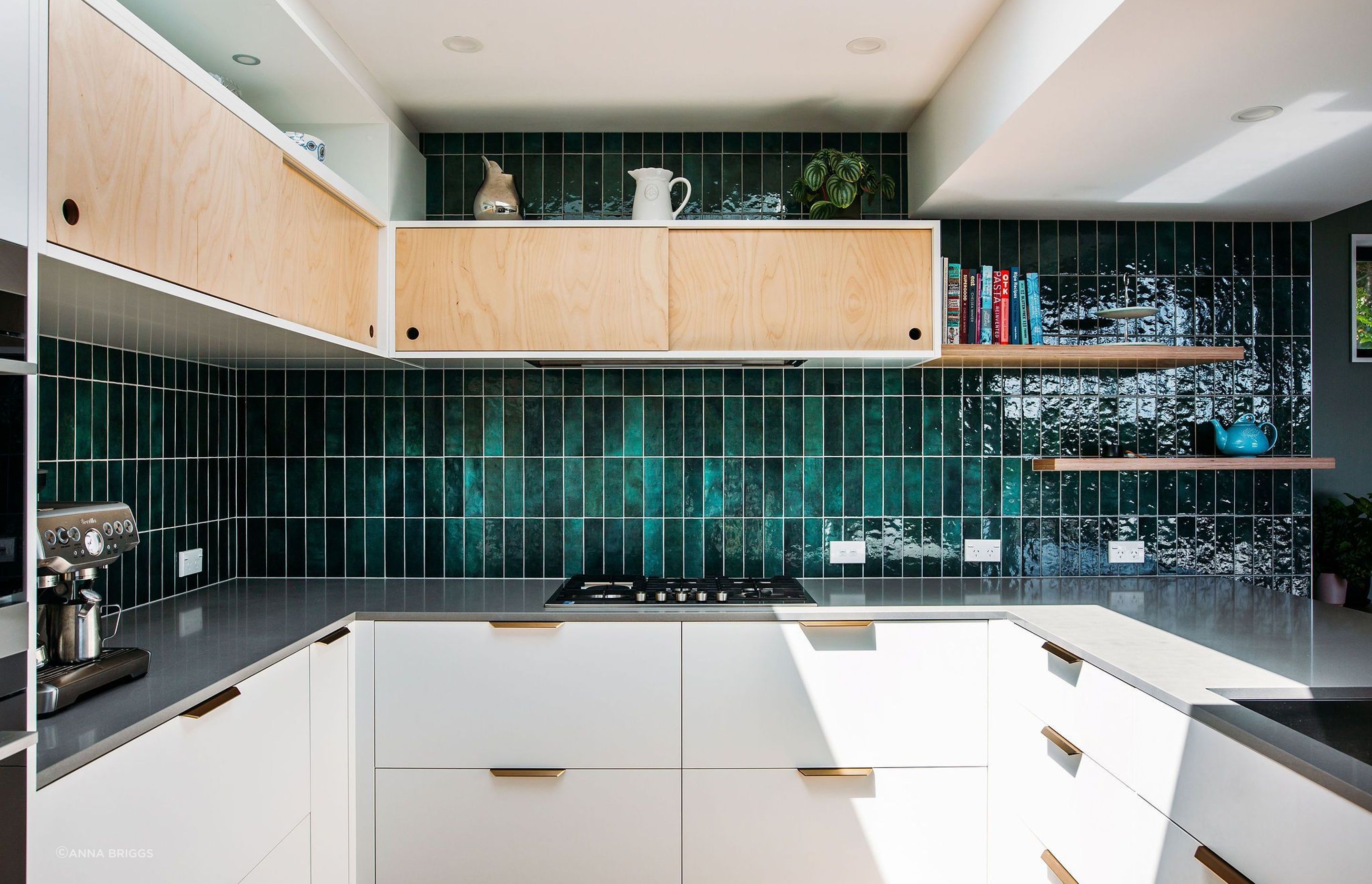 Simple plywood sliding cabinets above, brass pull handles below.