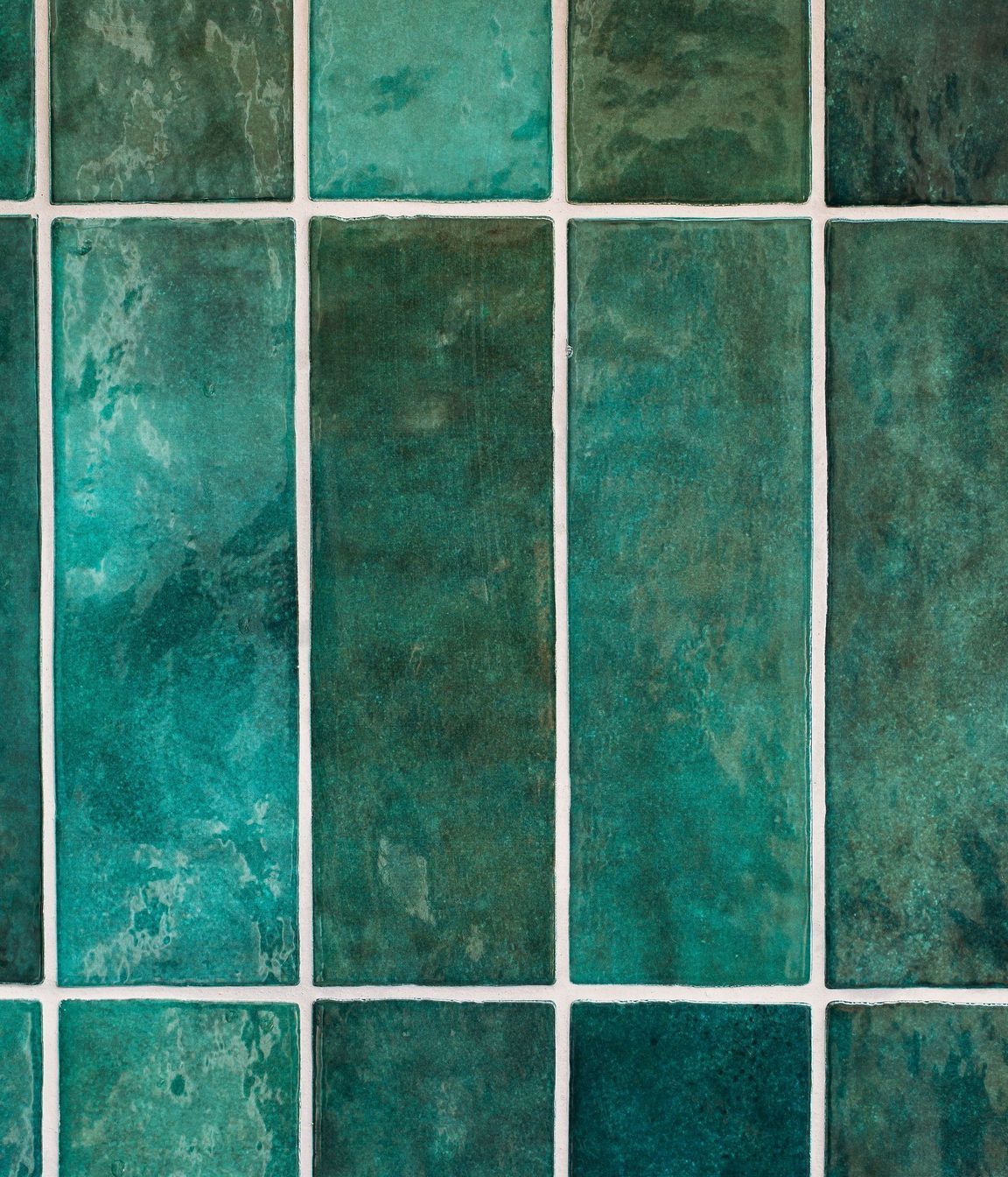 Emerald green tiles are laid vertically on the kitchen splashback.