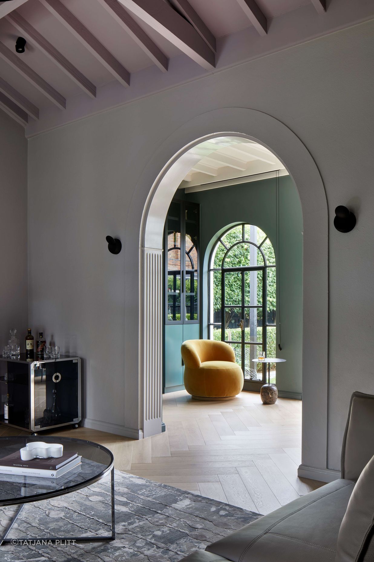 Arches on arches are repeated through this 1930’s art deco spanish mission style house renovation in suburban Melbourne. View through to the library with dark green walls (Paint colour Coriole from Dulux) and an occasional Joy chair in mustard elk velvet from Jardan. See more from our Arch Deco Project.