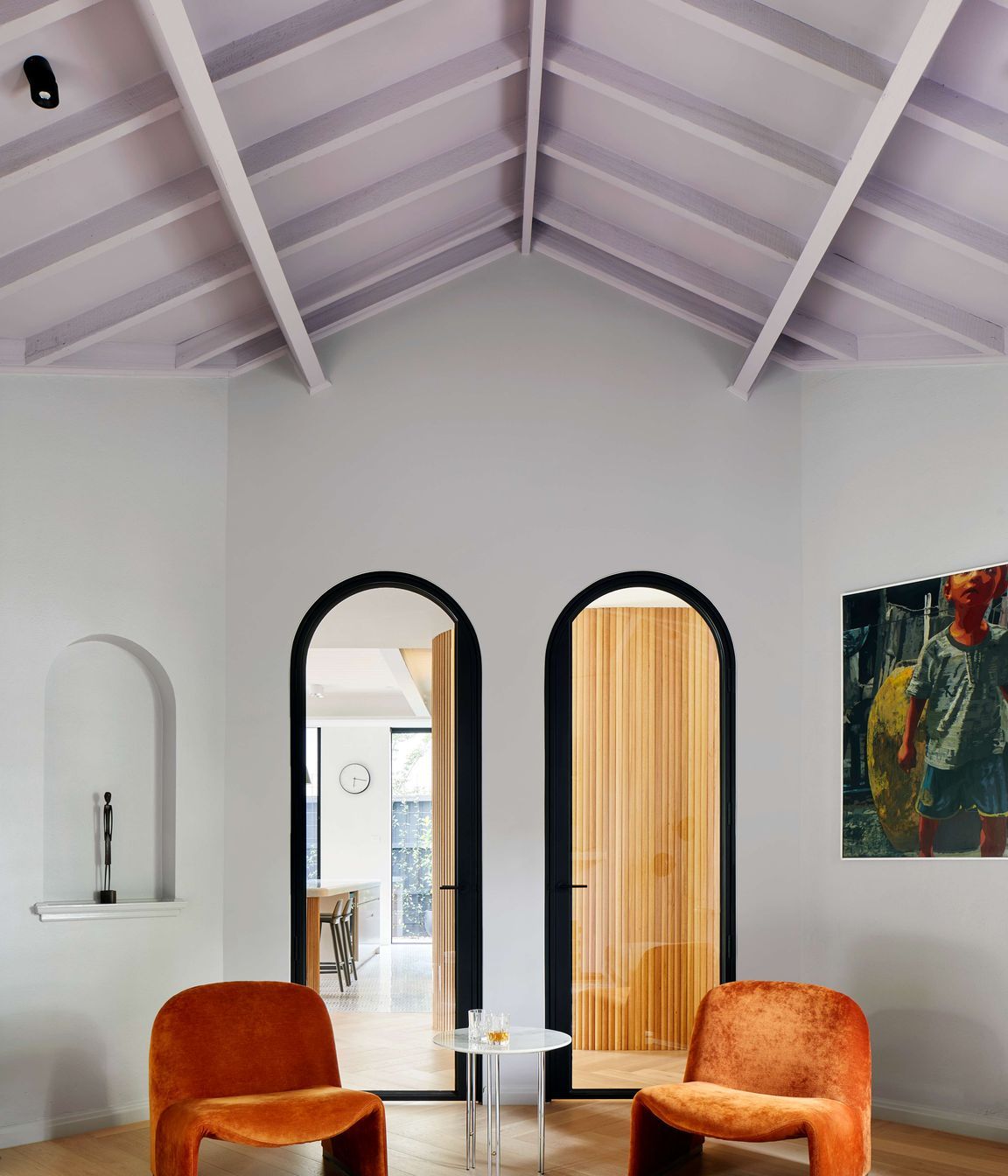 Living room featuring vaulted ceiling painted in mauve from Dulux, with arched doorways, Elke paprika velvet chairs from Castelli and oak flooring laid in herringbone pattern, with a matt lacquer, from our inner easter suburbs project in Melbourne, renovating a 1930’s spanish art deco home. See more from our Arch Deco Project