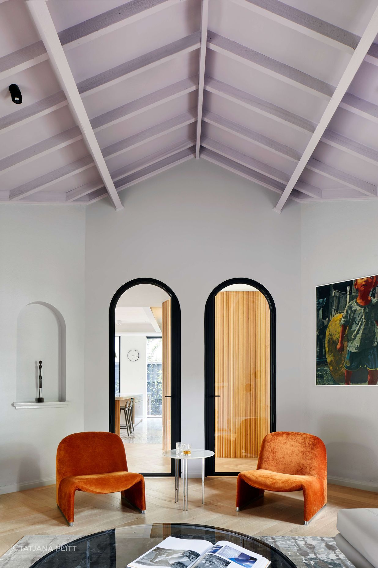 Living room featuring vaulted ceiling painted in mauve from Dulux, with arched doorways, Elke paprika velvet chairs from Castelli and oak flooring laid in herringbone pattern, with a matt lacquer, from our inner easter suburbs project in Melbourne, renovating a 1930’s spanish art deco home. See more from our Arch Deco Project