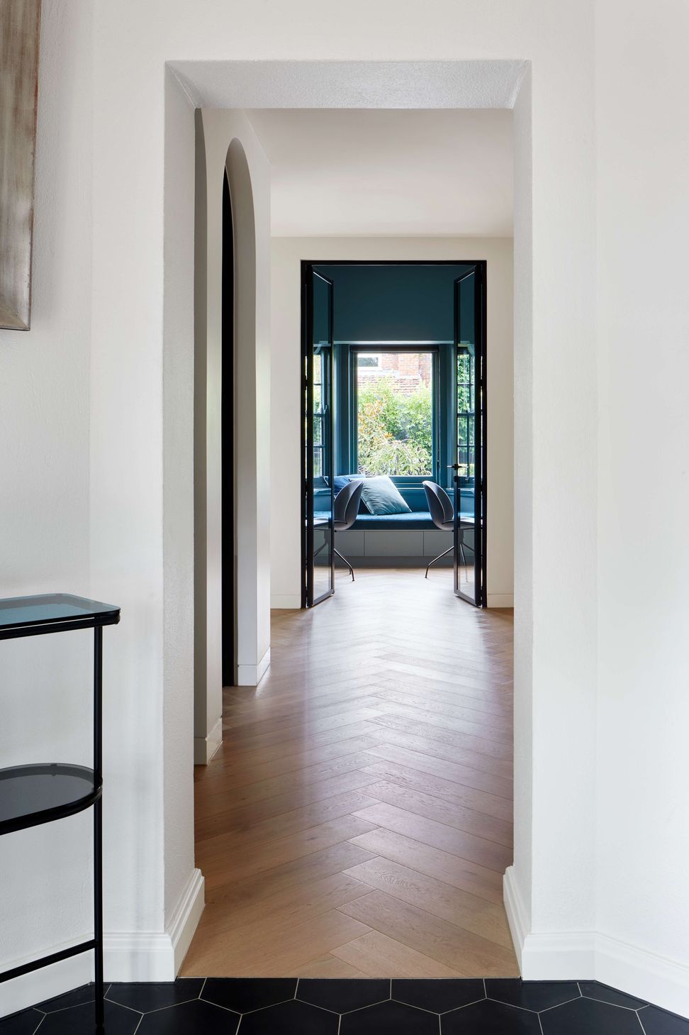 Hallway looking through to study featuring flooring is oak wood herringbone, as the central corridor to living and kitchen areas in this 1930s art deco renovation in Melbourne. See more from our Arch Deco Project.