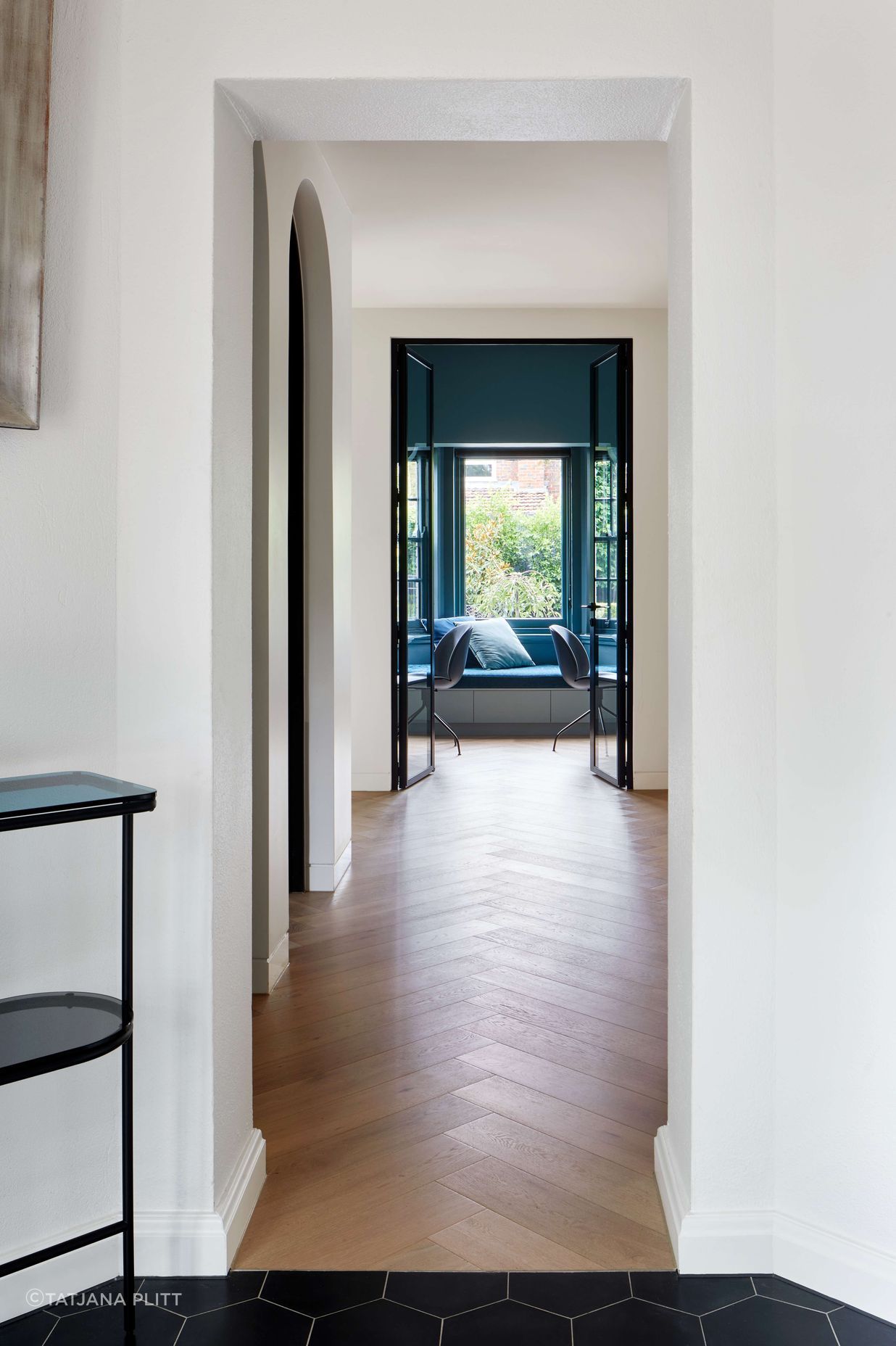 Hallway looking through to study featuring flooring is oak wood herringbone, as the central corridor to living and kitchen areas in this 1930s art deco renovation in Melbourne. See more from our Arch Deco Project.