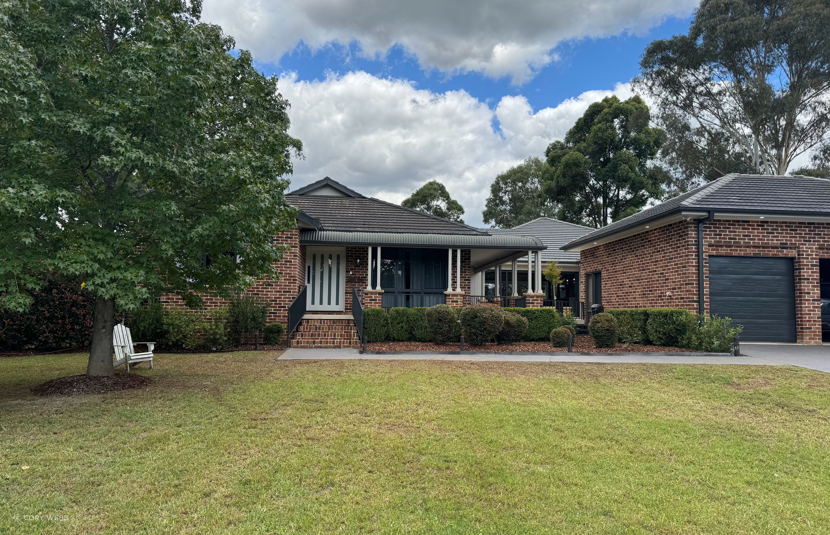 The street view of the red brick farmhouse only shows a small slice of the surprising addition to the rear of the property.