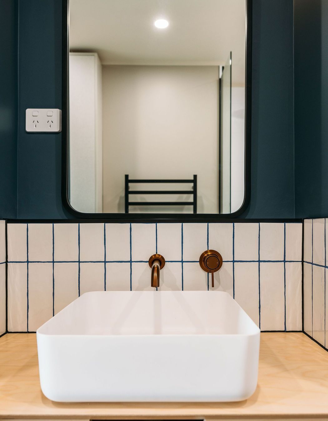 Gorgeous grout, copper tapware and plywood bring the materials palette into the bathroom.