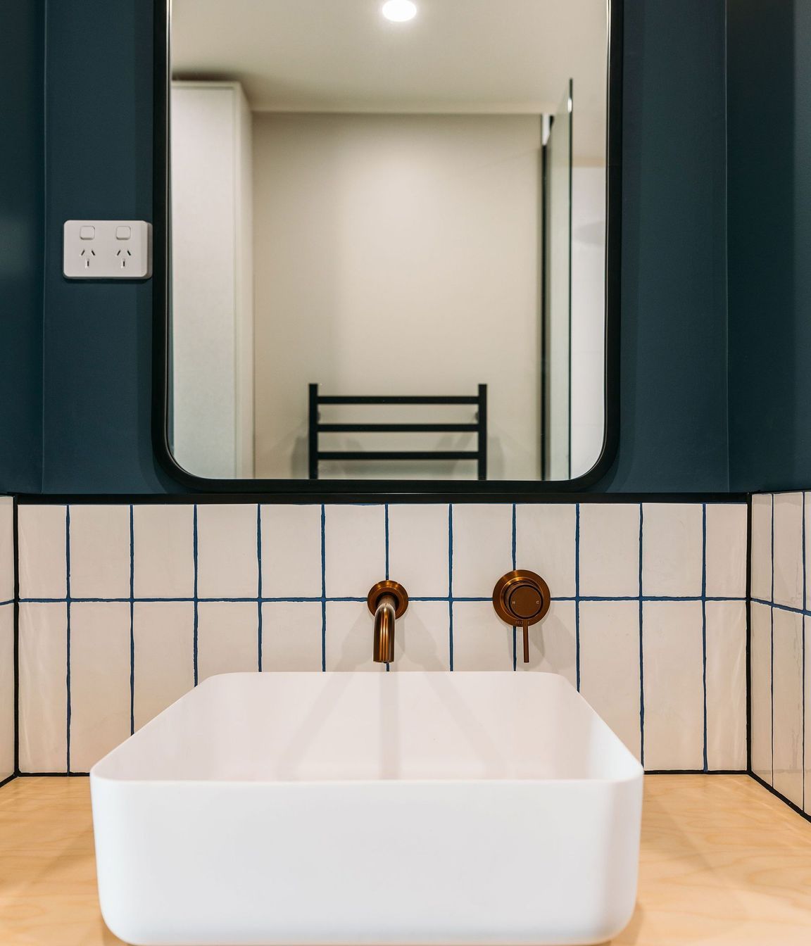 Gorgeous grout, copper tapware and plywood bring the materials palette into the bathroom.