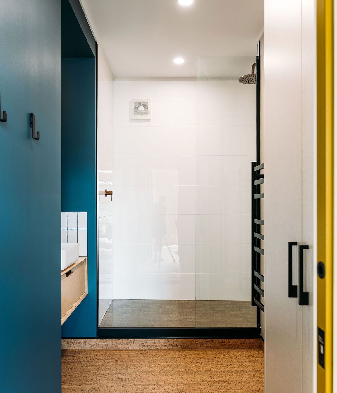 A step up into the shower was retained in the penthouse bathroom to work around existing plumbing constraints.