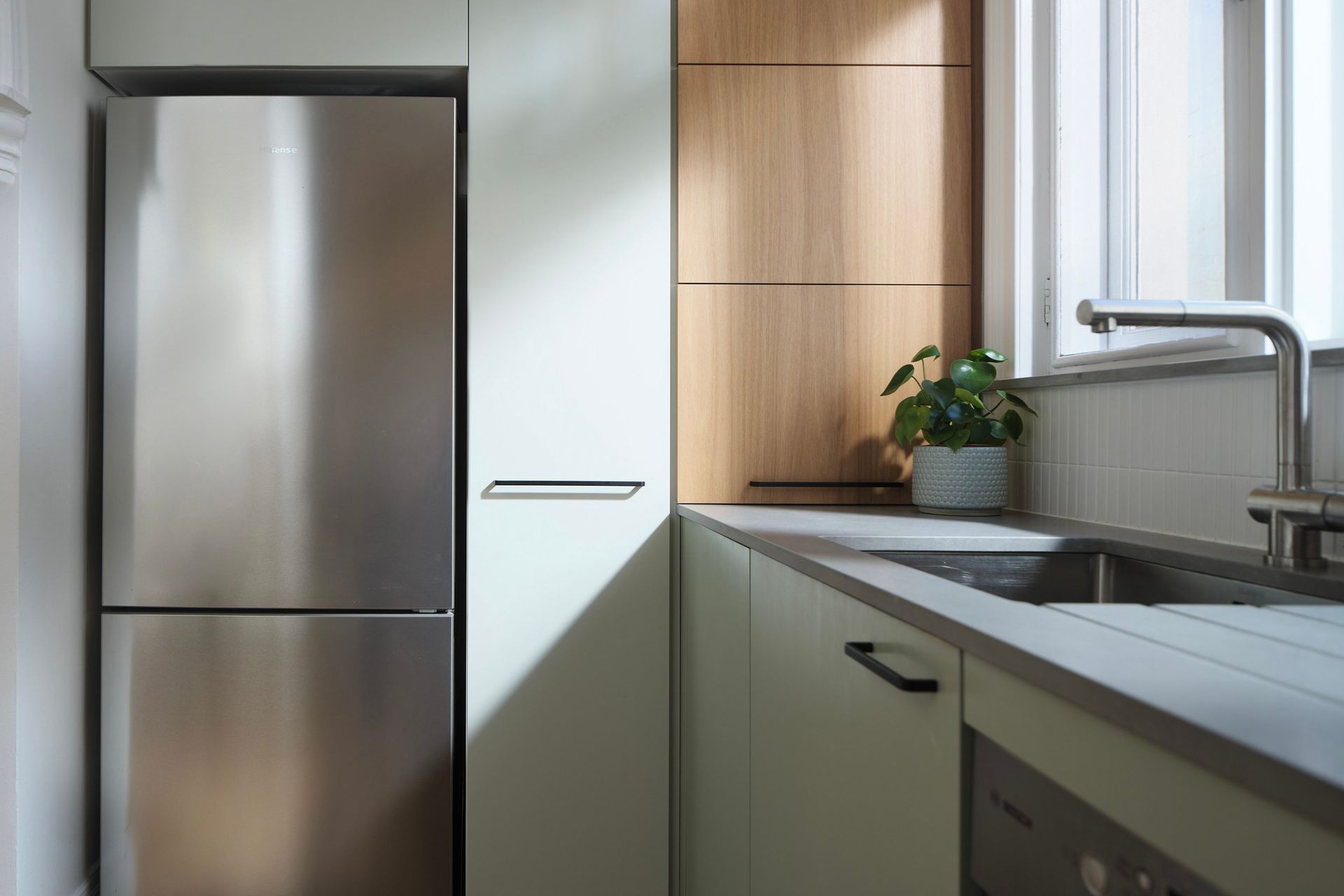 We created a mix of hand painted light green doors to break up and provide contrast against Blackbutt veneer panels.
