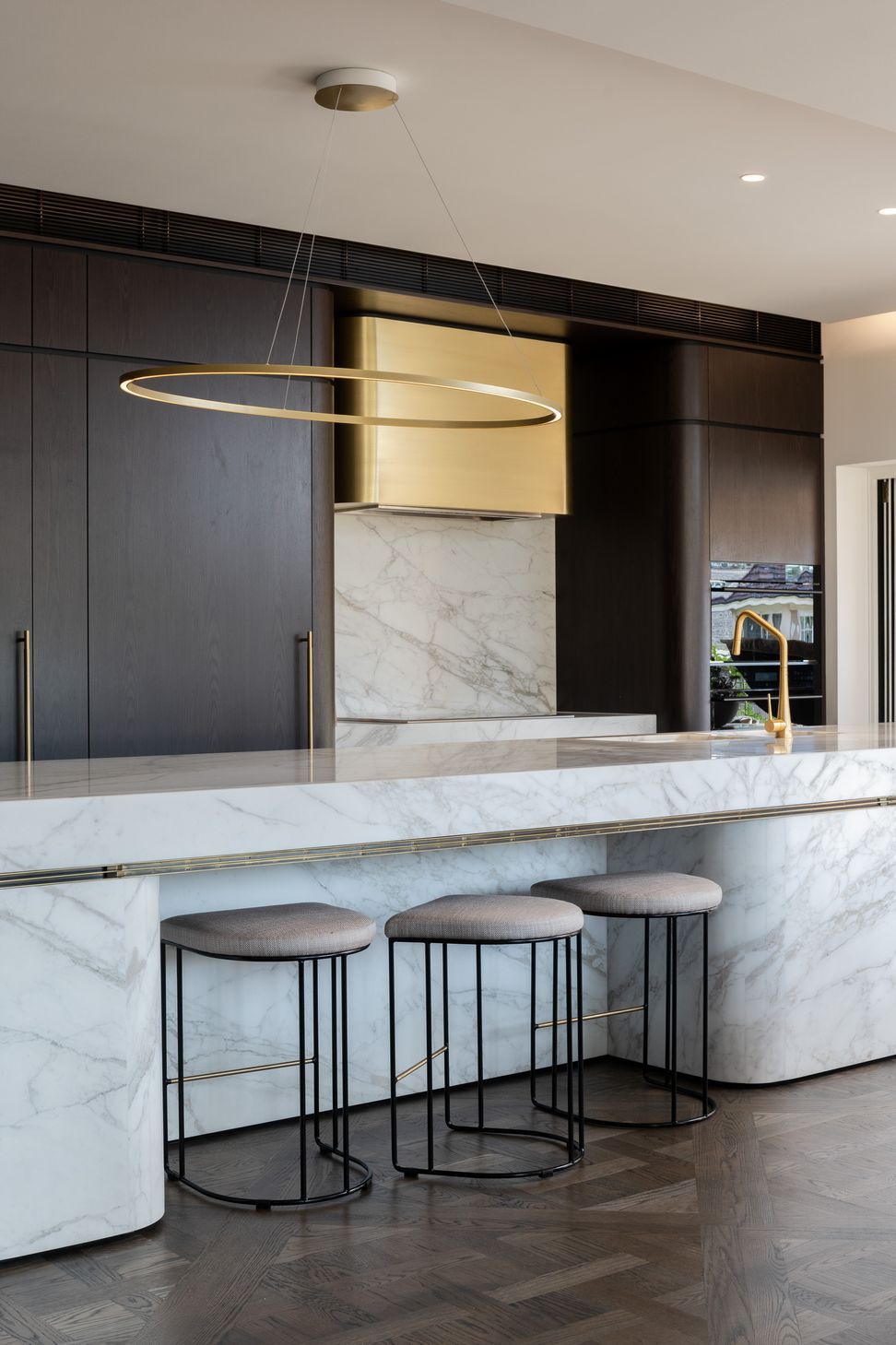 Curved marble bench and bespoke brass range hood