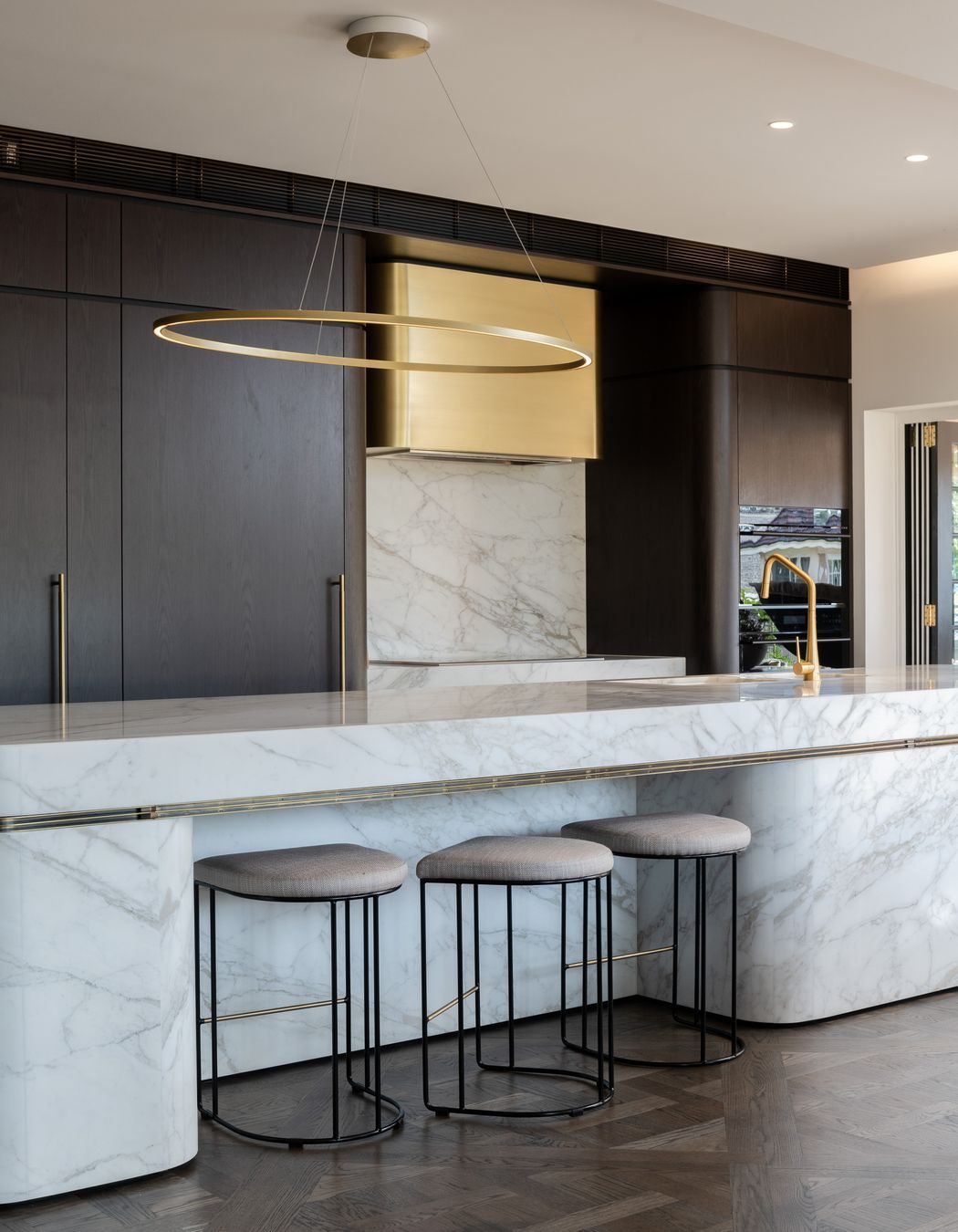 Curved marble bench and bespoke brass range hood