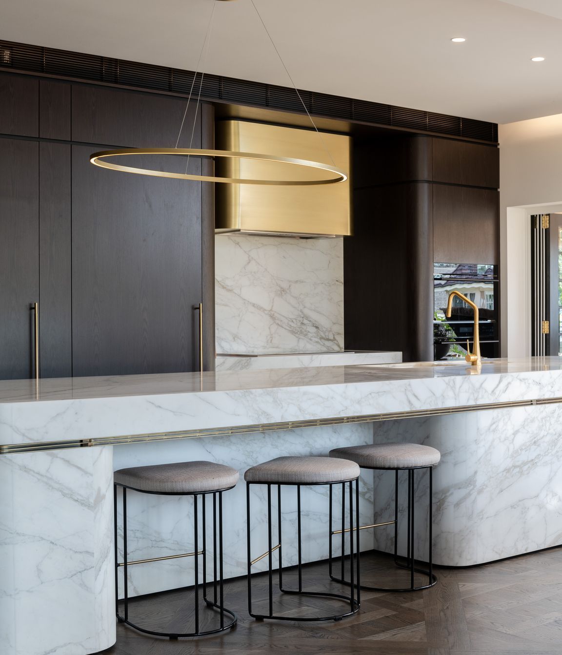Curved marble bench and bespoke brass range hood