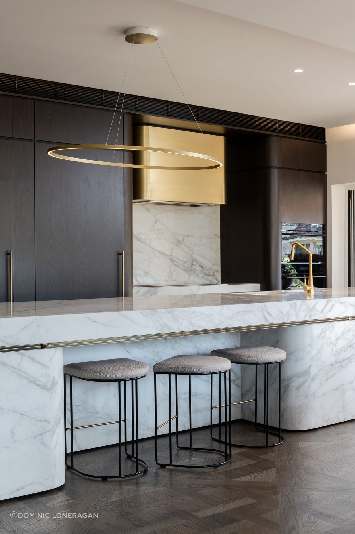 Curved marble bench and bespoke brass range hood