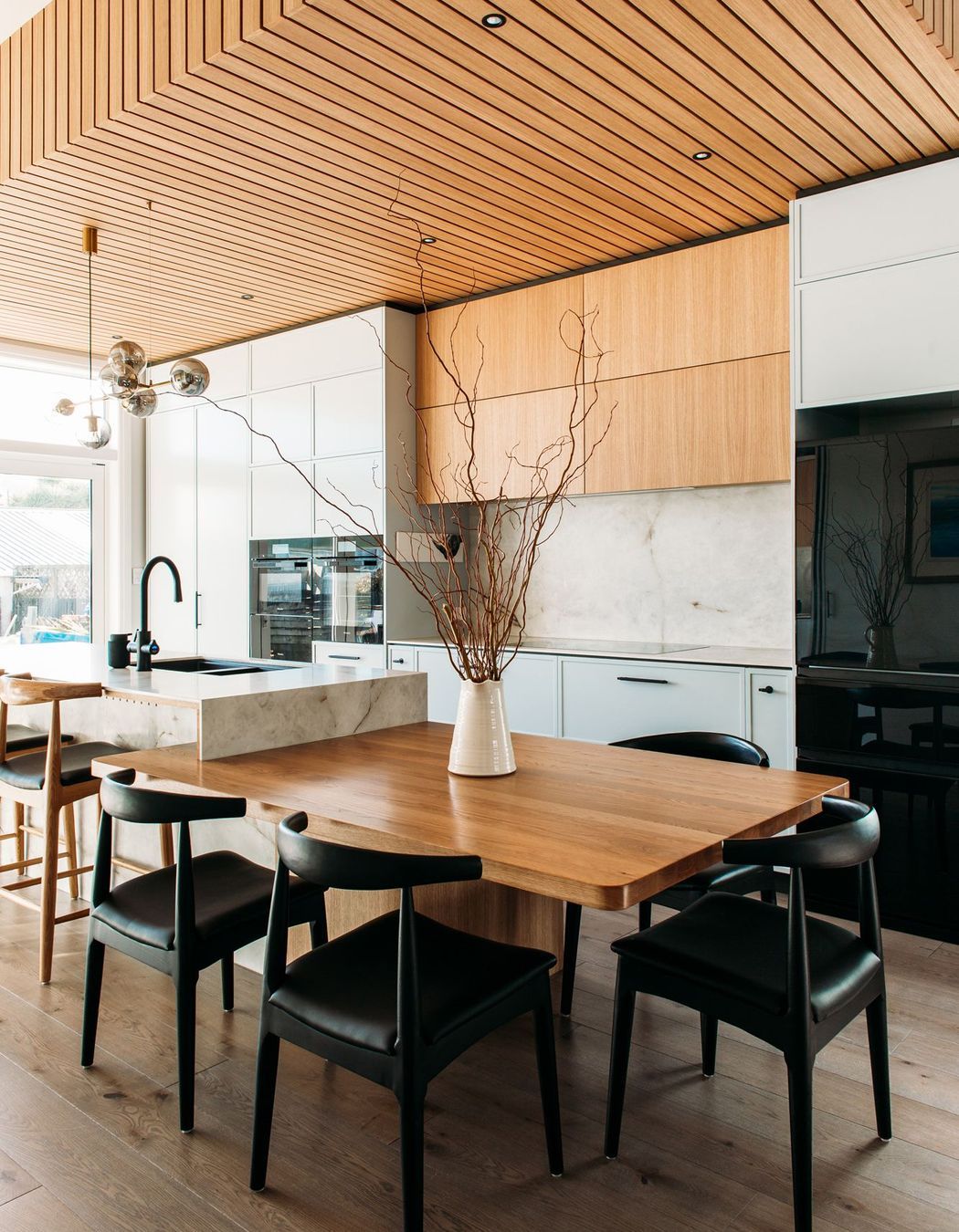 A solid oak dining table was designed into the benchtop to create efficient space planning.
