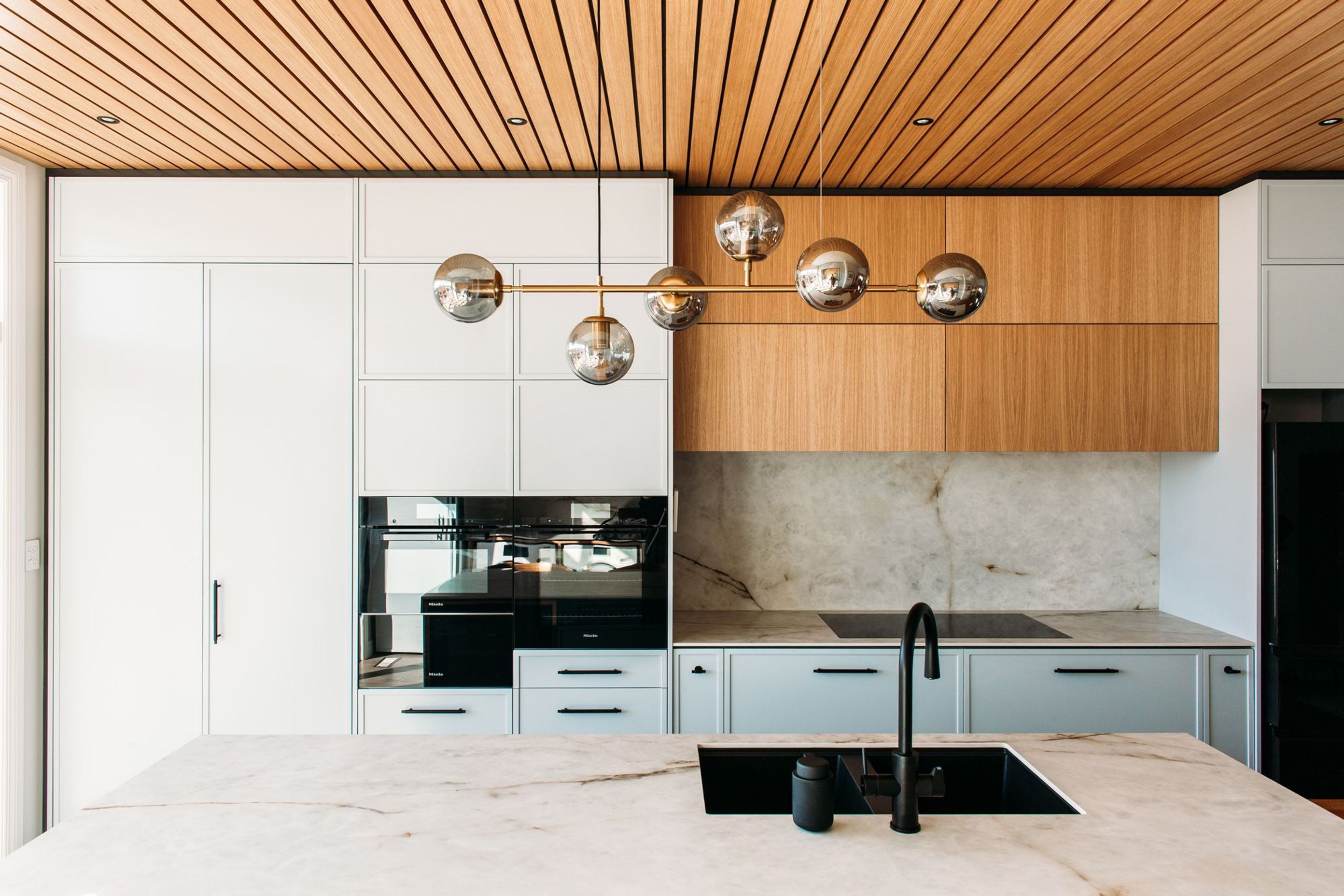 The smoke and brass pendant light features above the island, and is a perfect soft light for when sitting at the dining table.