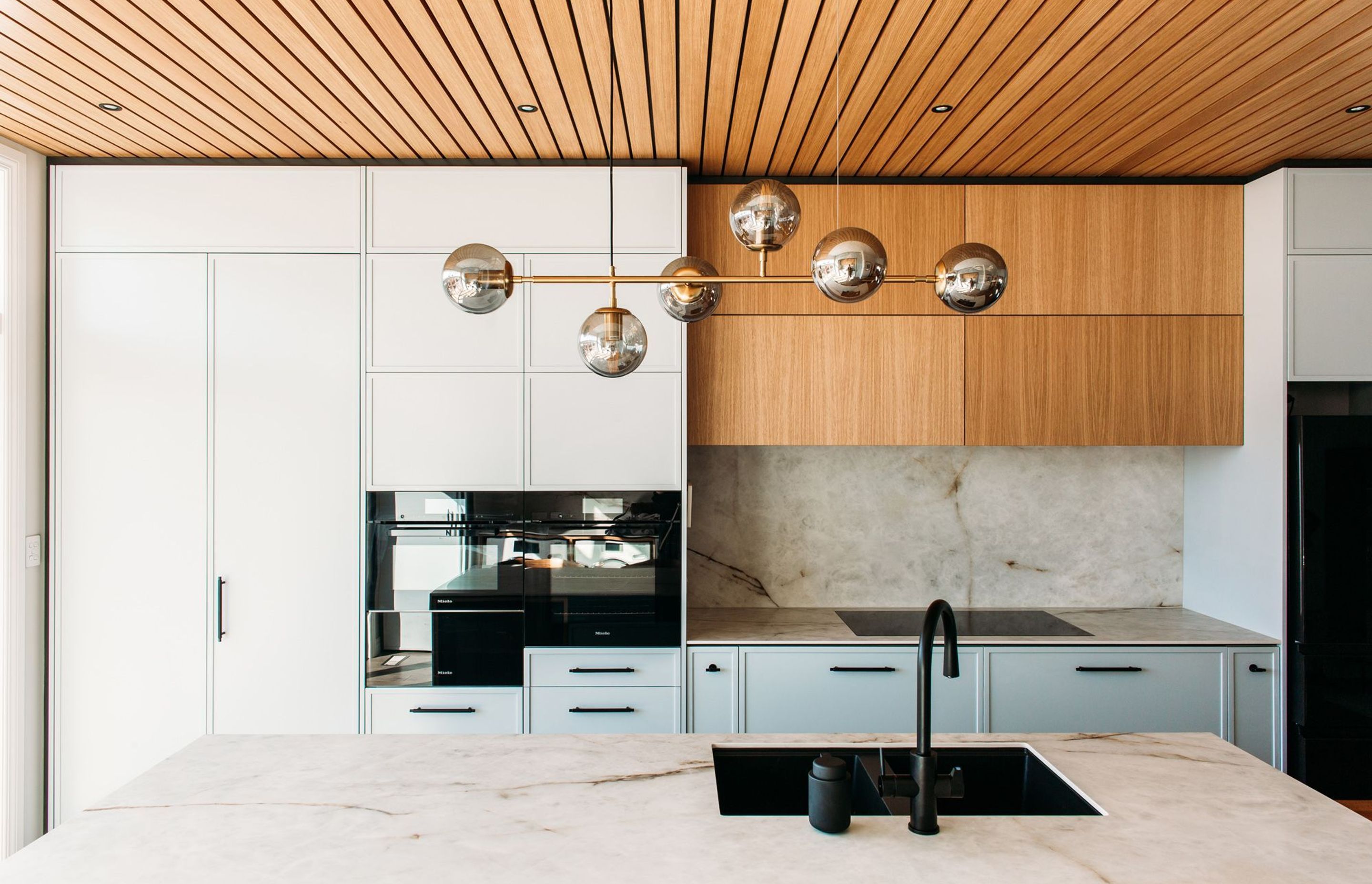 The smoke and brass pendant light features above the island, and is a perfect soft light for when sitting at the dining table.