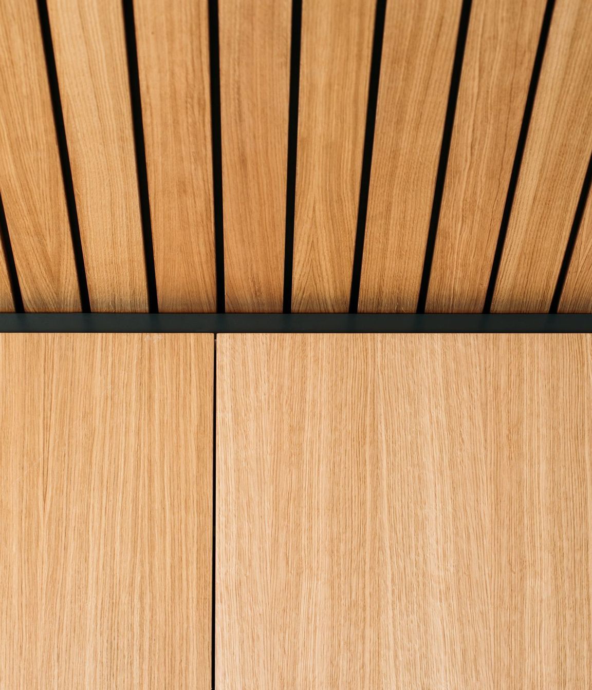 Matt black negative detail is added above the cabinetry to meet the ceiling feature.