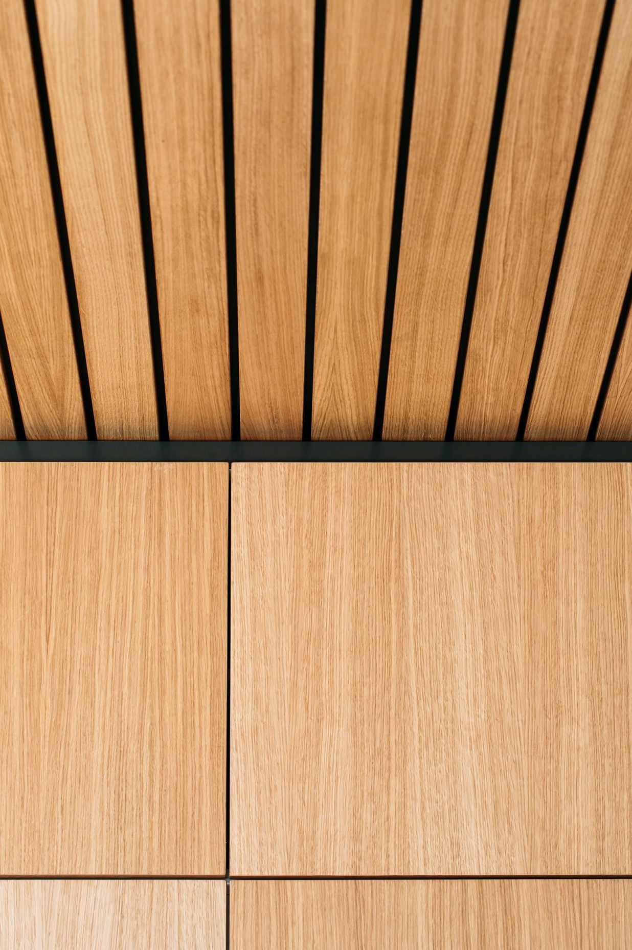 Matt black negative detail is added above the cabinetry to meet the ceiling feature.