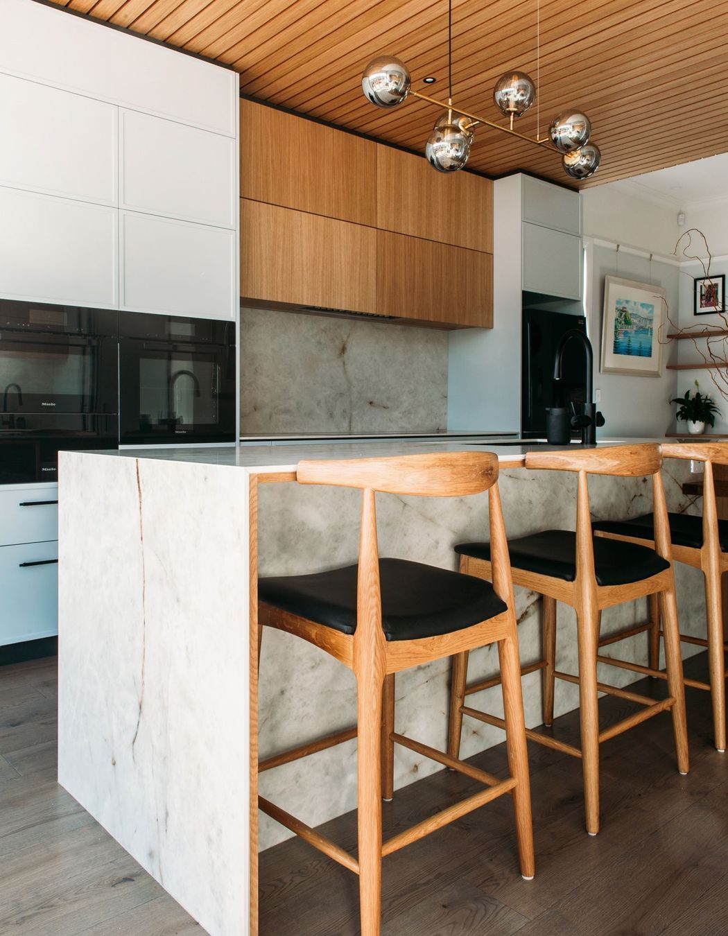 The porcelain benchtop has a waterfall end and ample overhang for the bar stools.